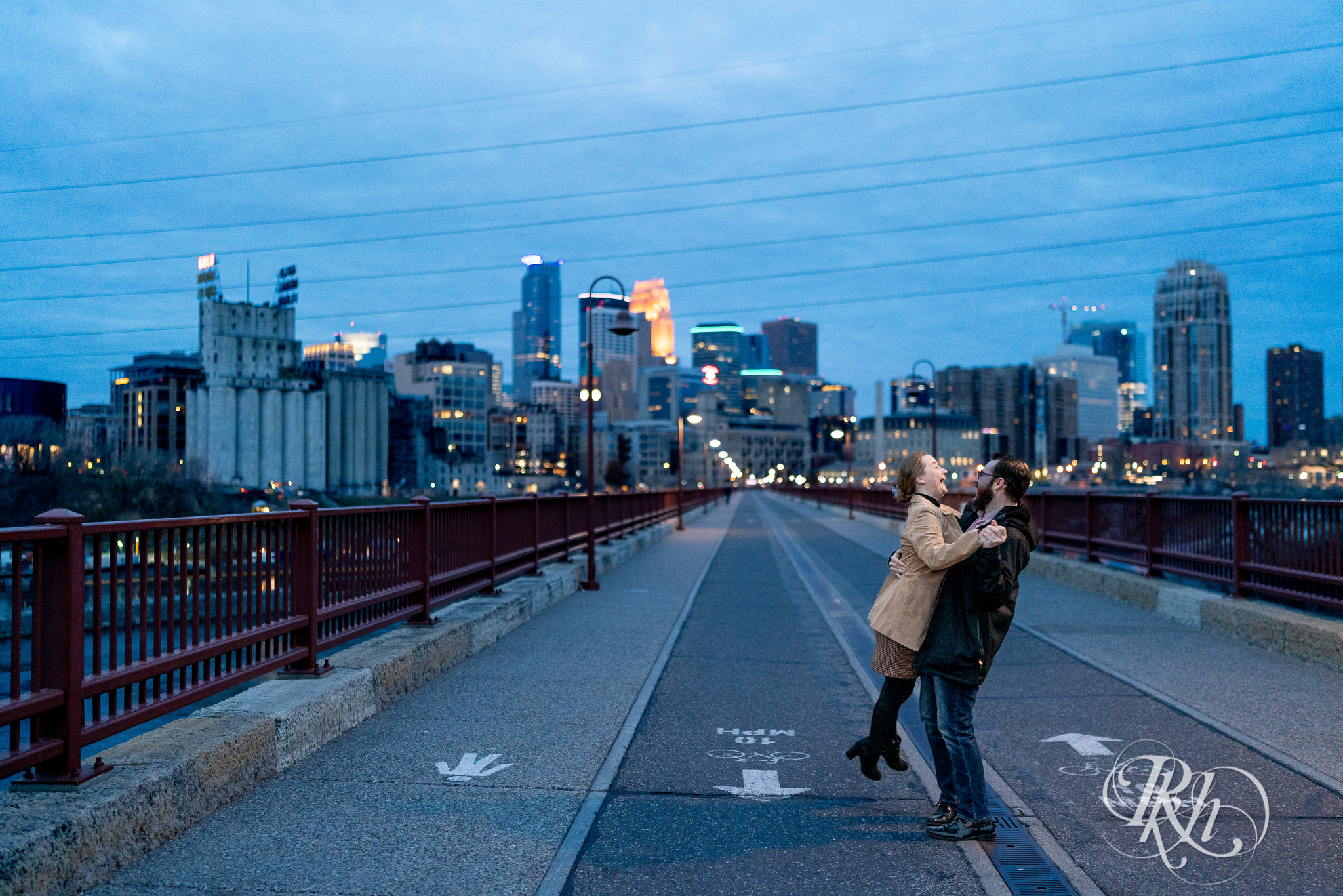 Man and woman dancing on the Stone Arch Bridge in Minneapolis, Minnesota at sunrise.