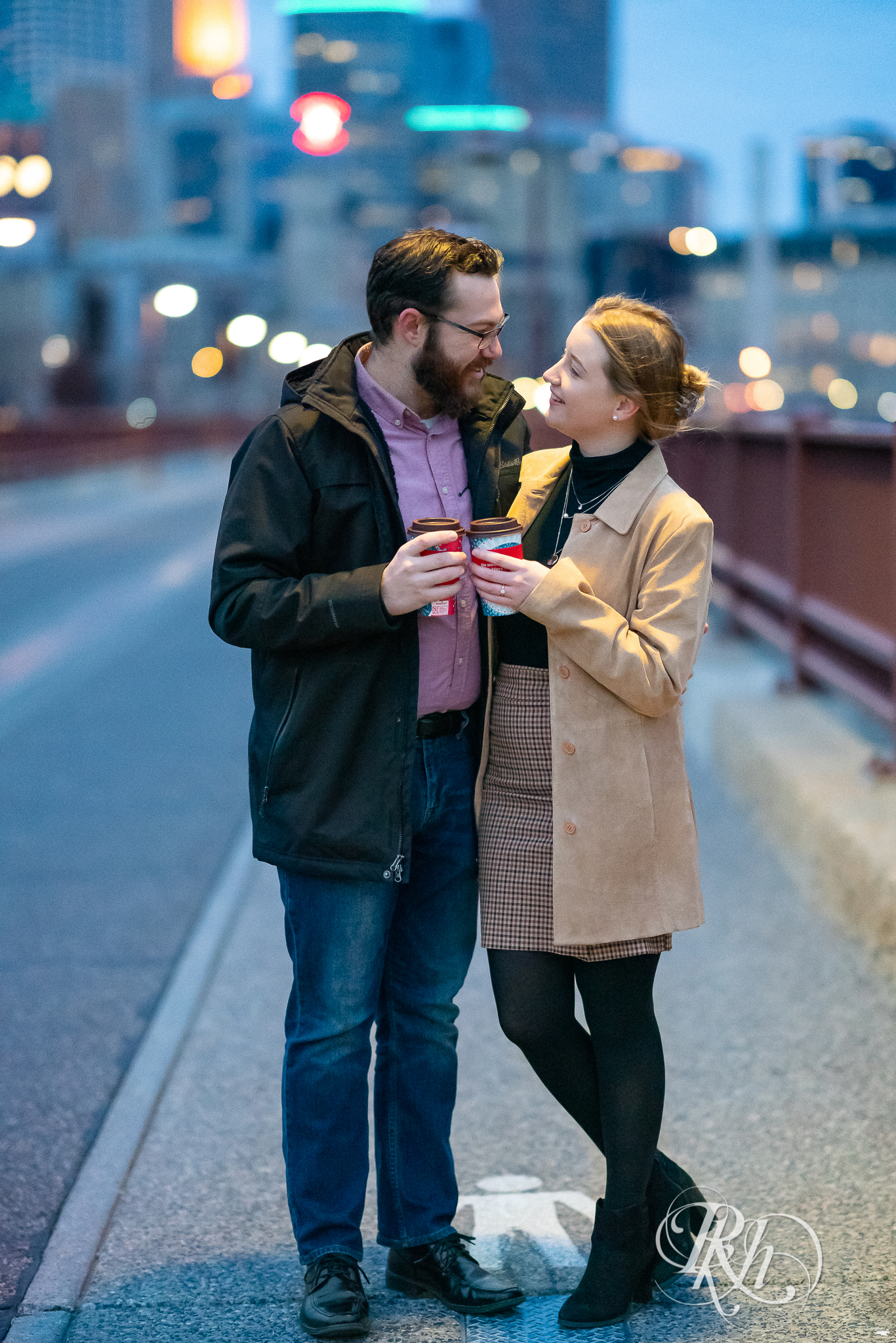 Man and woman drinking Caribou Coffee on the Stone Arch Bridge in Minneapolis, Minnesota at sunrise.