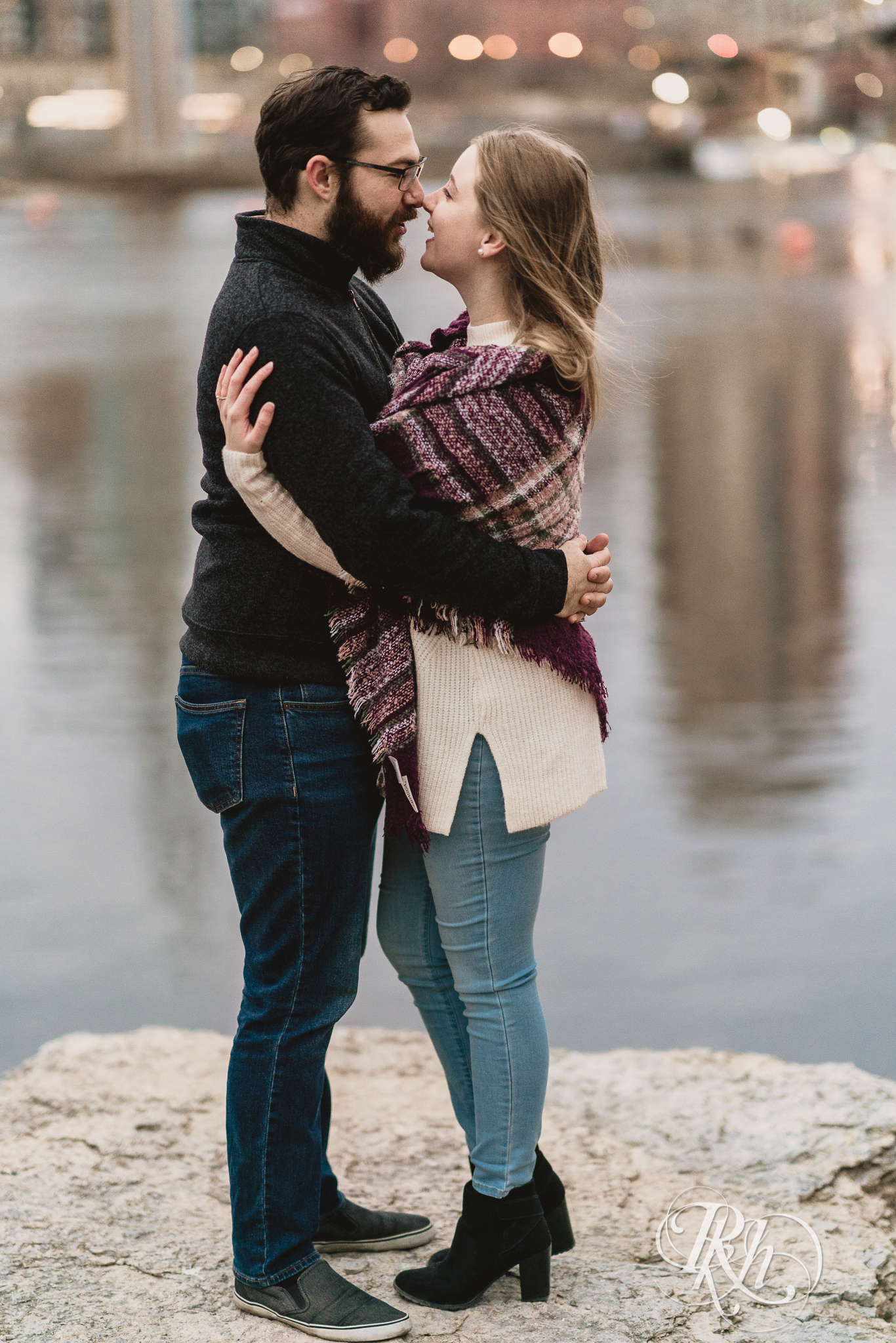 Man and woman hugging in front of Mississippi River in Minneapolis, Minnesota at sunrise. 