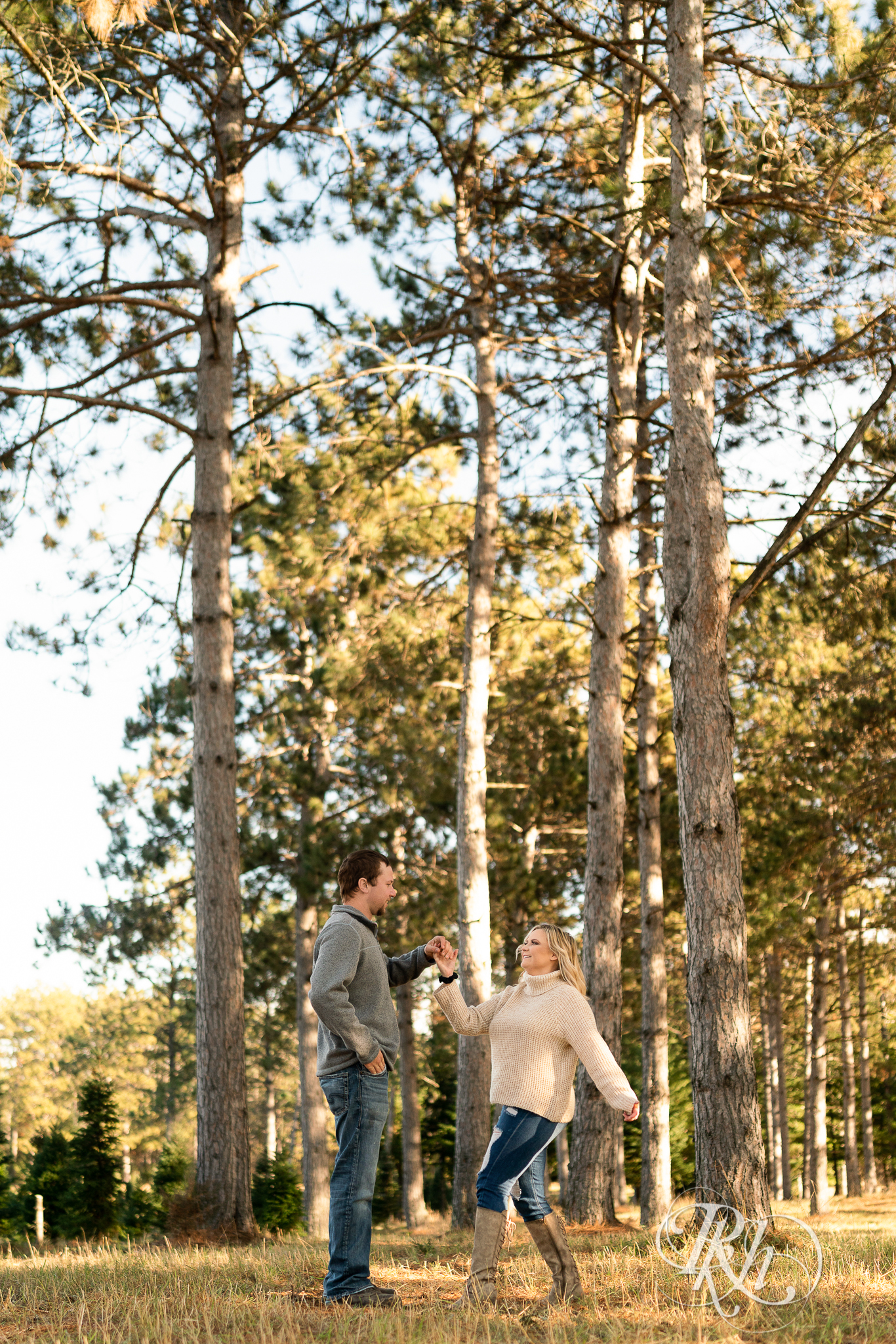 Man and woman dancing in between trees at Hansen Tree Farm in Anoka, Minnesota.