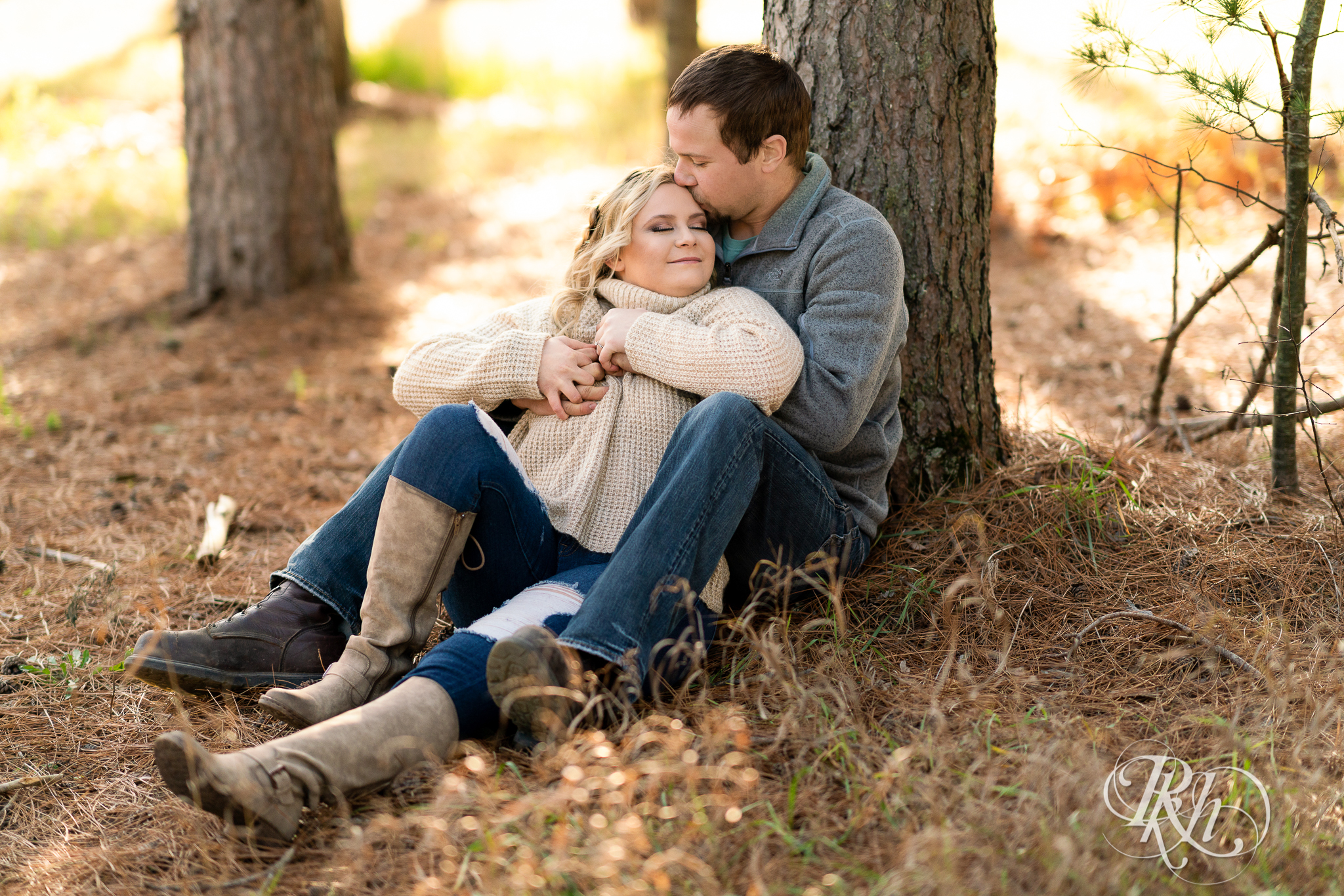Man and woman snuggling in front of a tree at Hansen Tree Farm in Anoka, Minnesota.