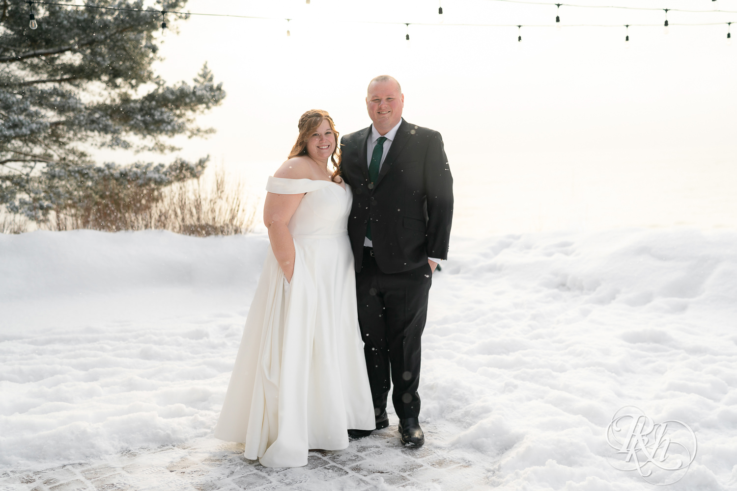 Bride and groom smiling in the snow at Grand Superior Lodge in Two Harbors, Minnesota.