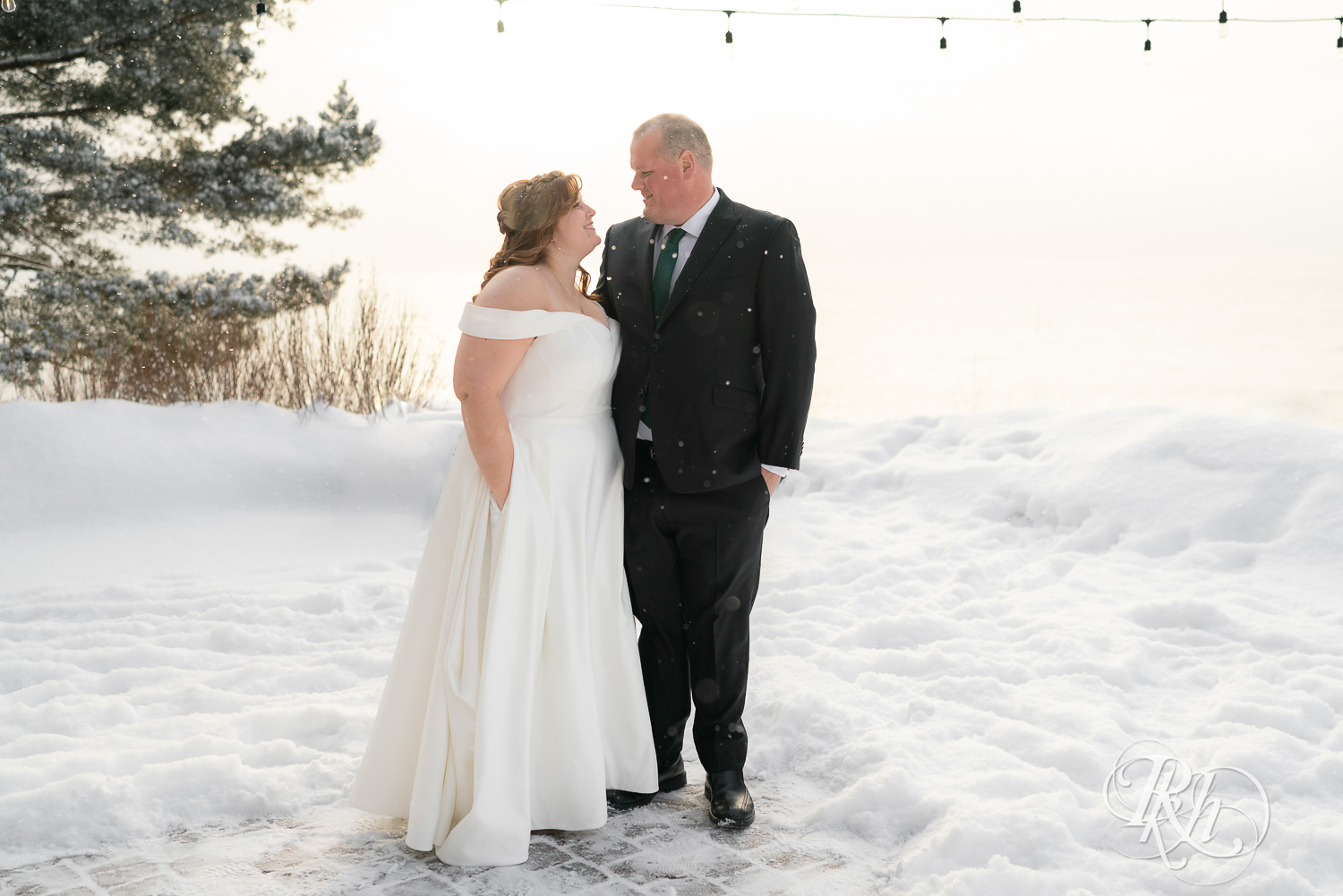Bride and groom smiling in the snow at Grand Superior Lodge in Two Harbors, Minnesota.