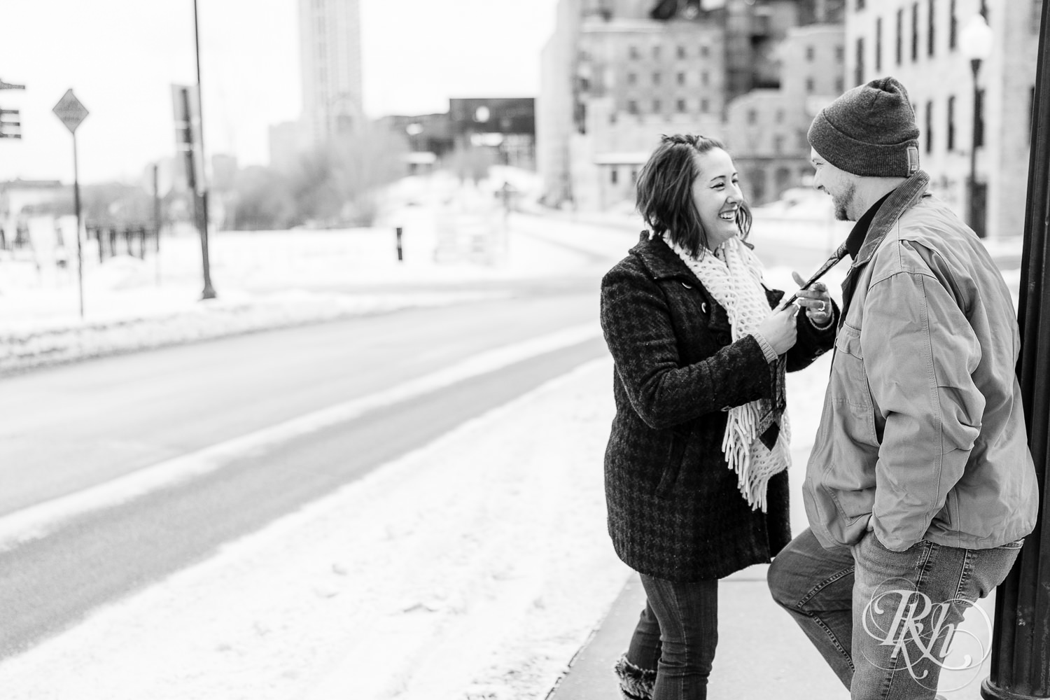 Man and woman dancing in snow in front of the Stone Arch Bridge in Minneapolis, Minnesota.