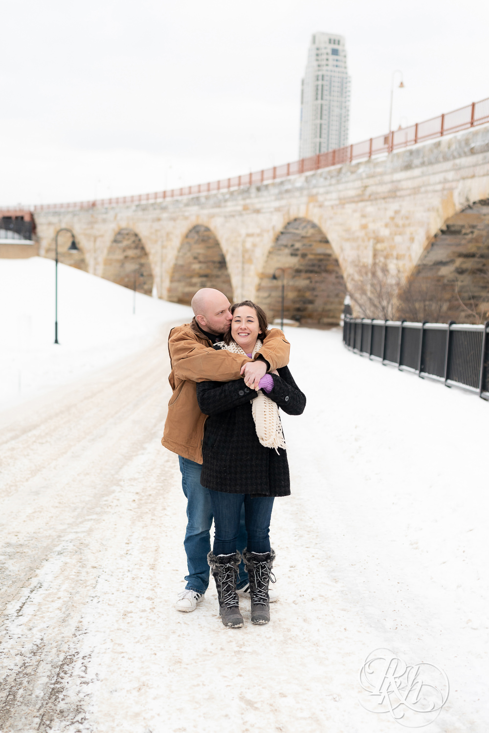 Man kisses woman in snow at Mill City Ruins in Minneapolis, Minnesota.