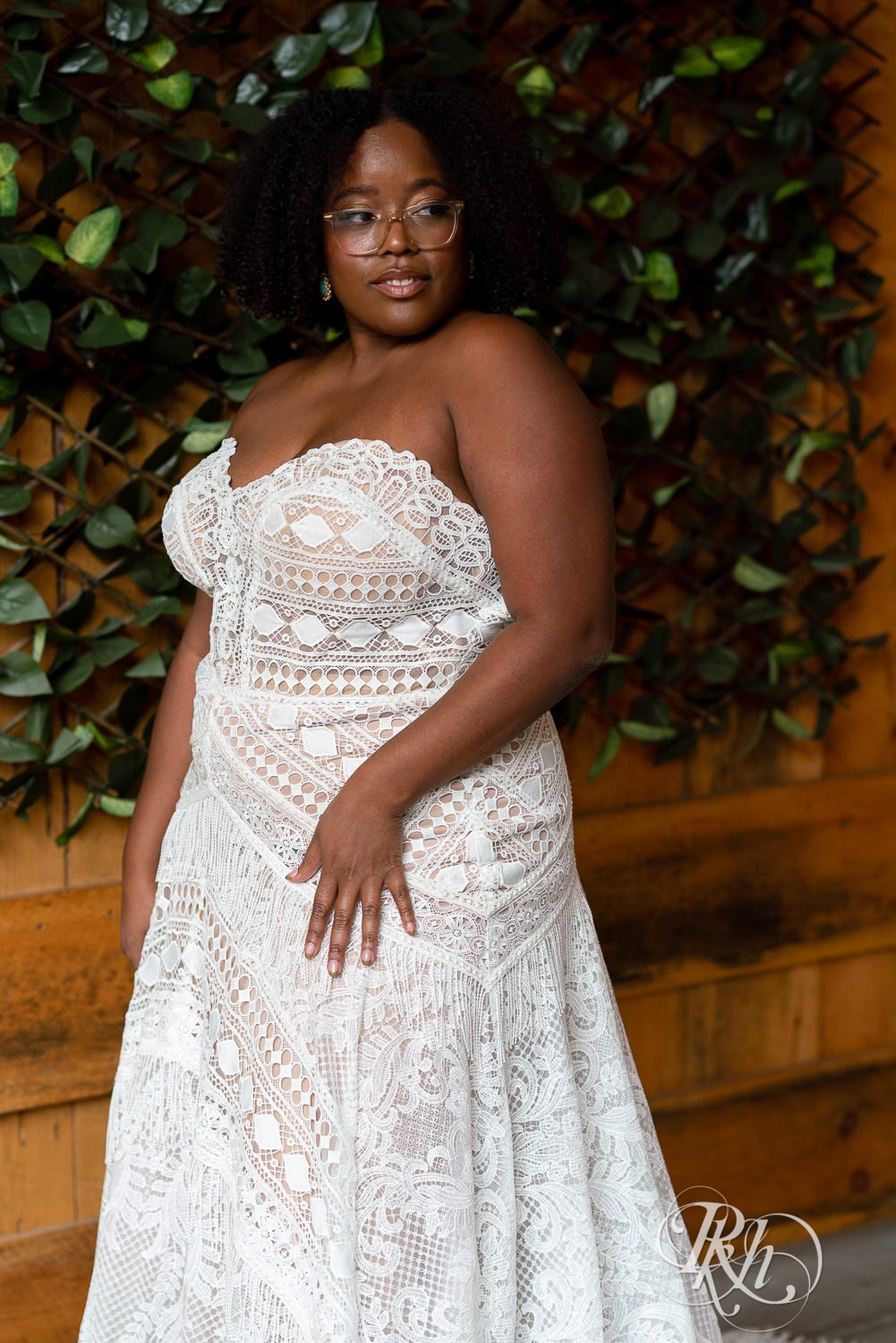 Black plus size bride looking over shoulder in wedding dresses in Minneapolis, Minnesota.