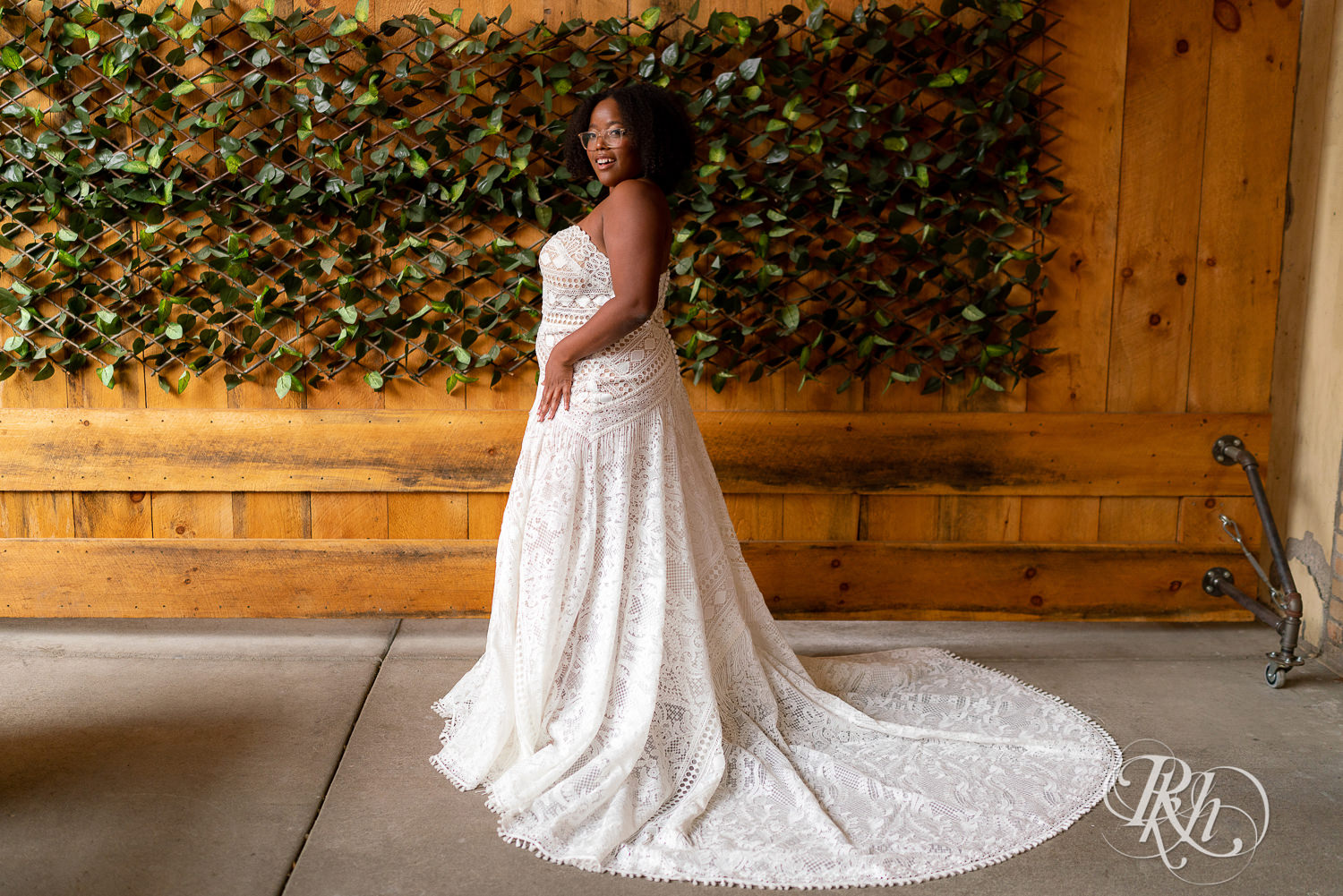 Black plus size bride looking over shoulder in wedding dresses in Minneapolis, Minnesota.