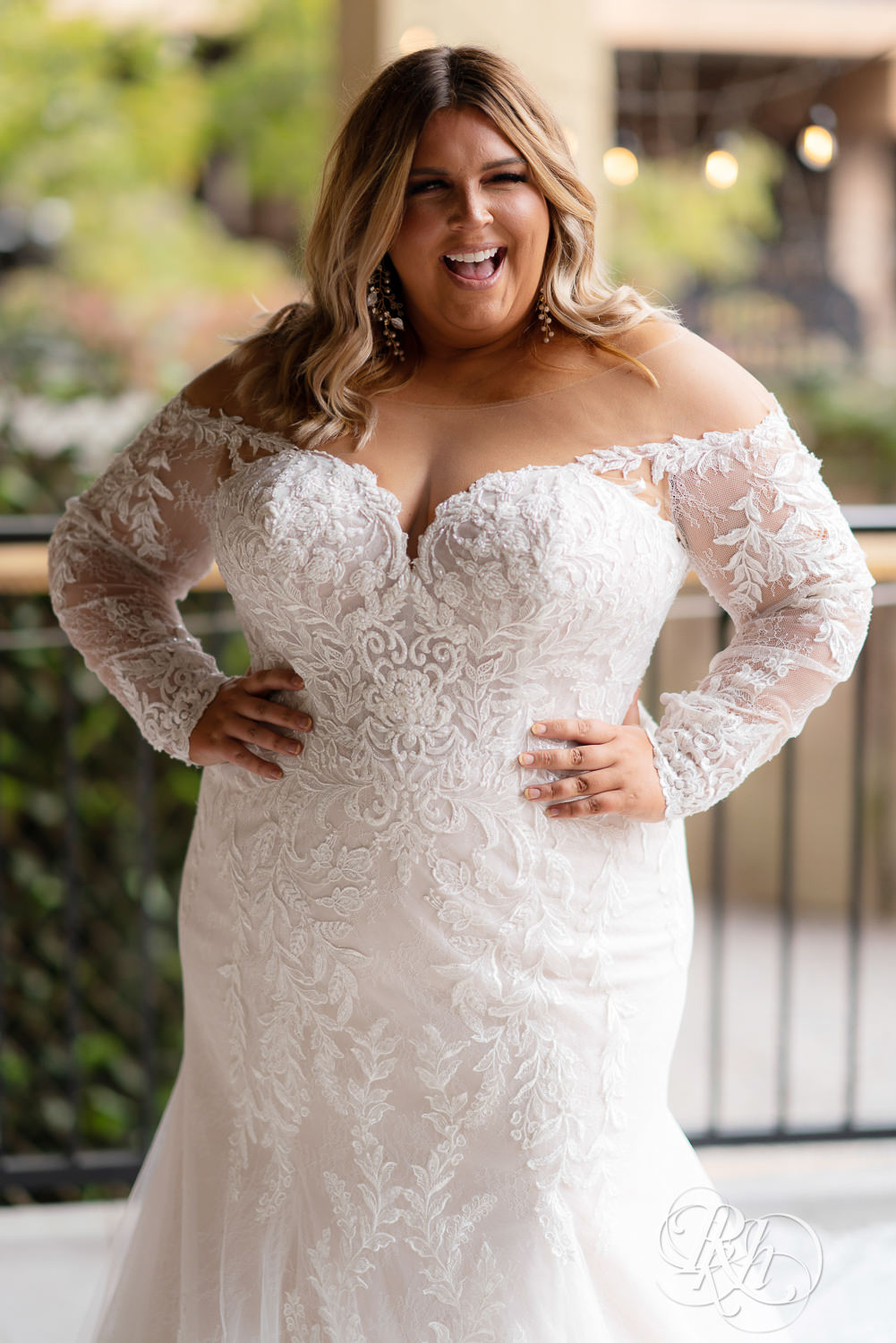 Plus size bride smiling and winking in wedding dresses in Minneapolis, Minnesota with hand on hip.