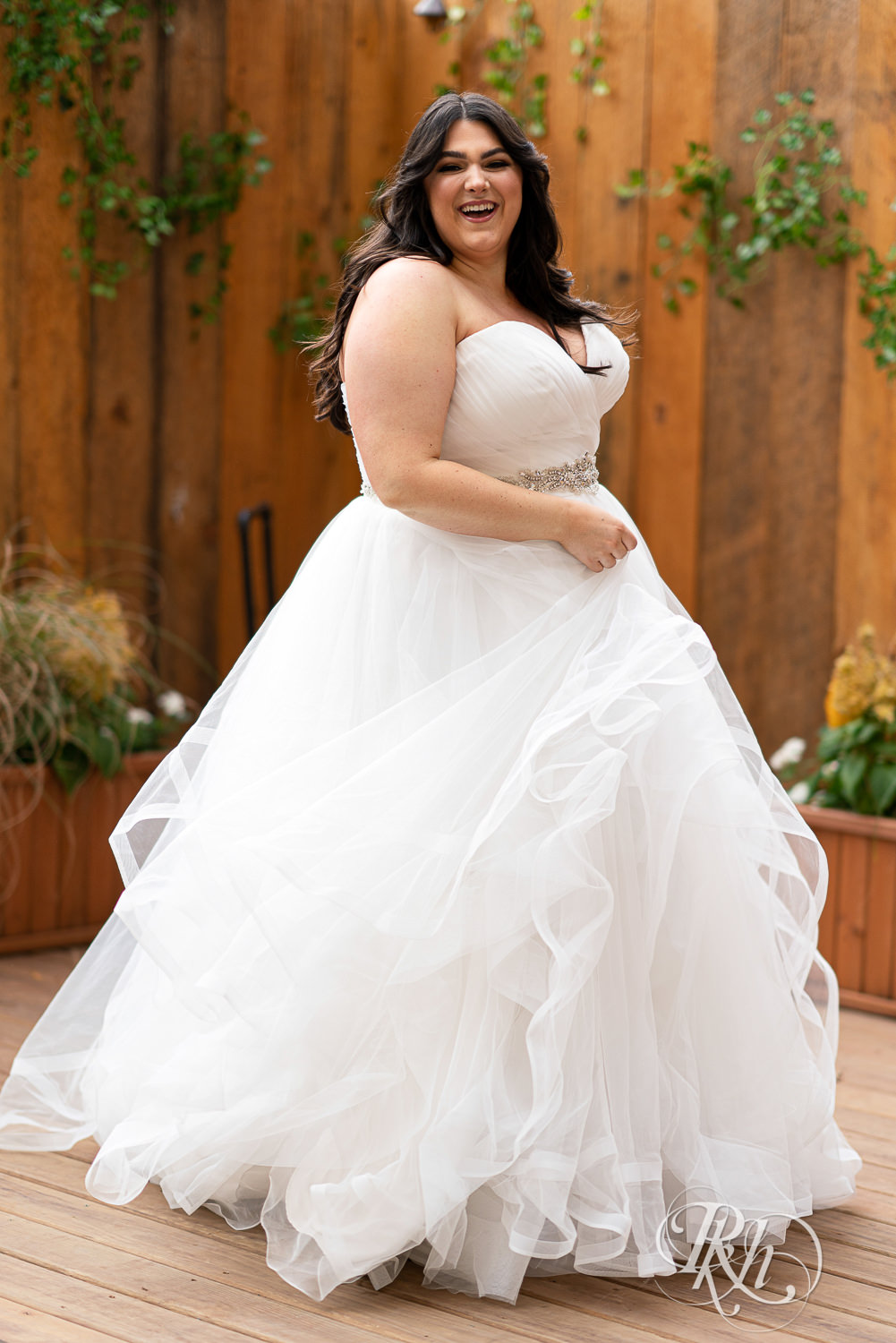 Plus size bride dancing in lacy wedding dress in Minneapolis, Minnesota.