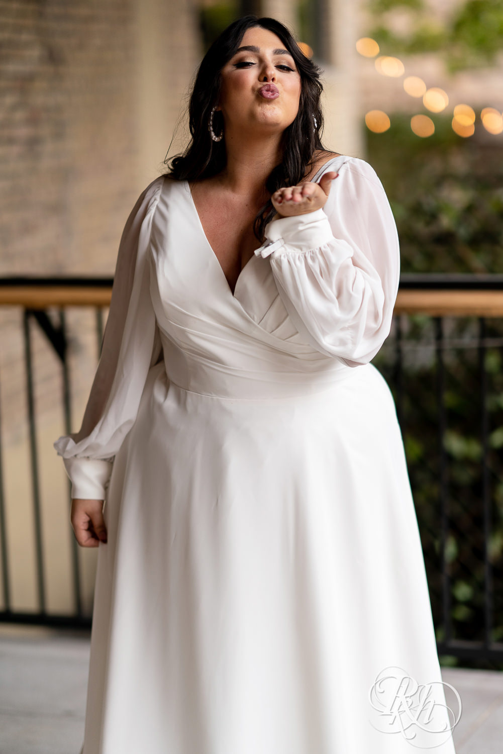 Plus size bride smiling in wedding dresses in Minneapolis, Minnesota blowing kiss.