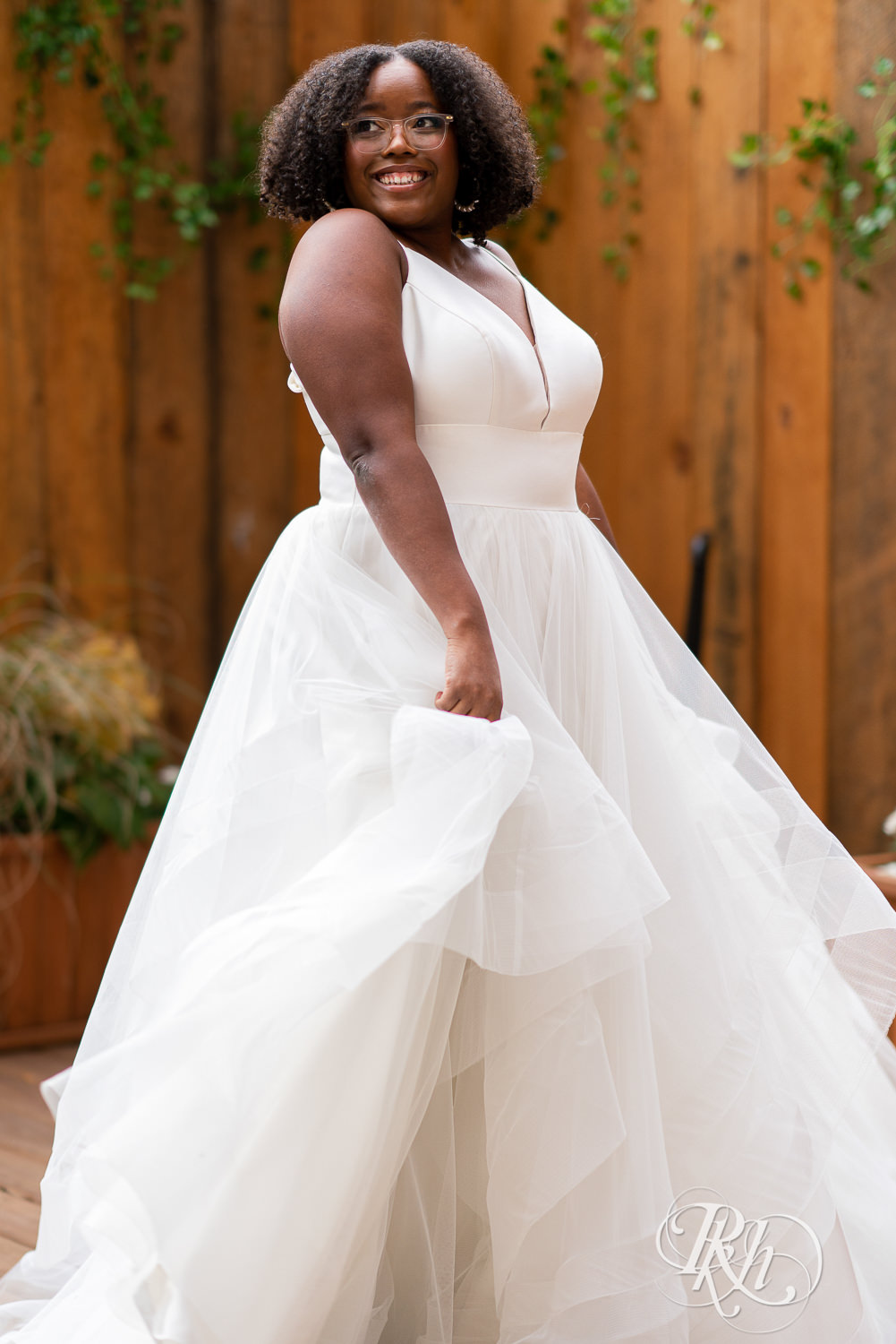 Black plus size bride with glasses dancing in wedding dress in Minneapolis, Minnesota.