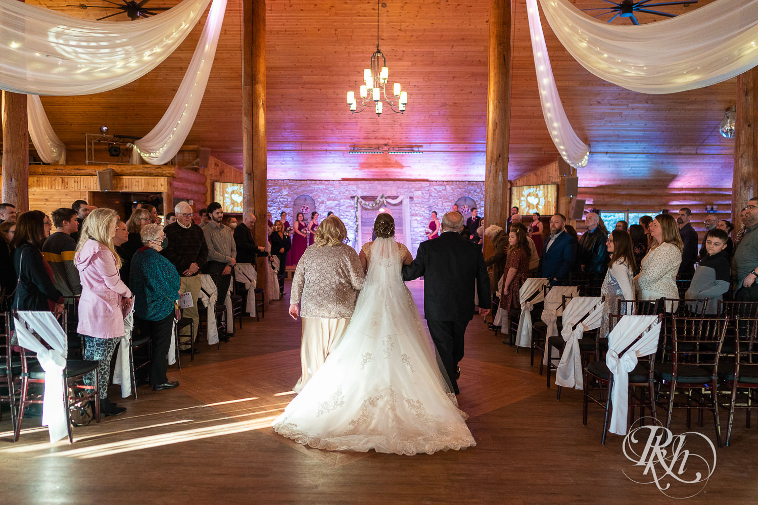 Bride walking down aisle with parents at Glenhaven Events in Farmington, Minnesota.