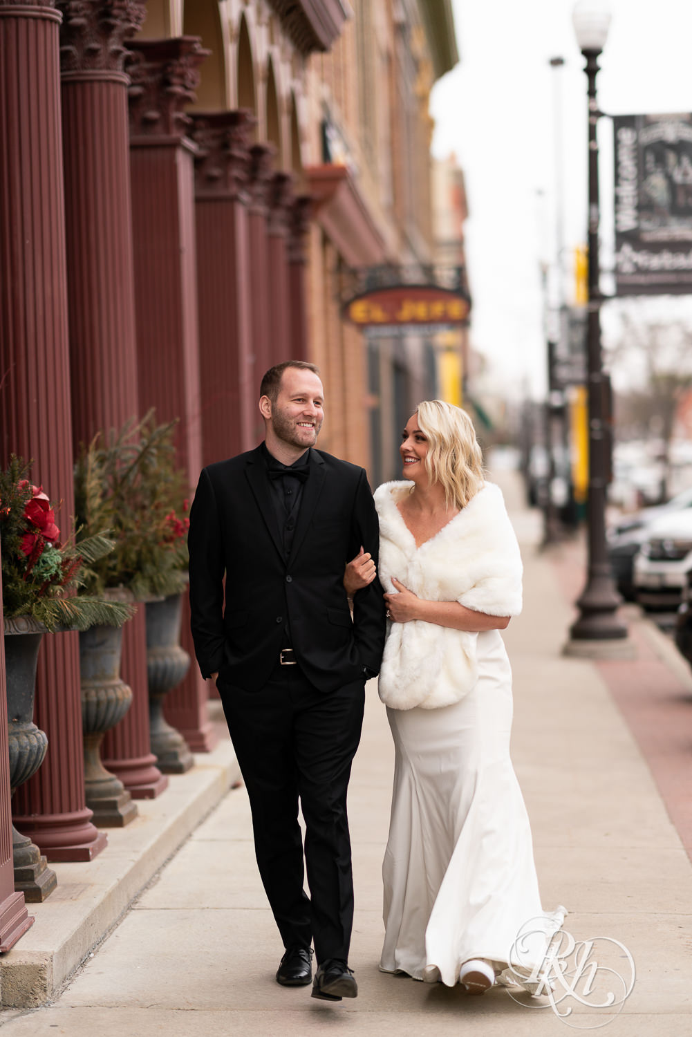 Bride and groom walking down road in front of 3 Ten Event Venue in Faribault, Minnesota.