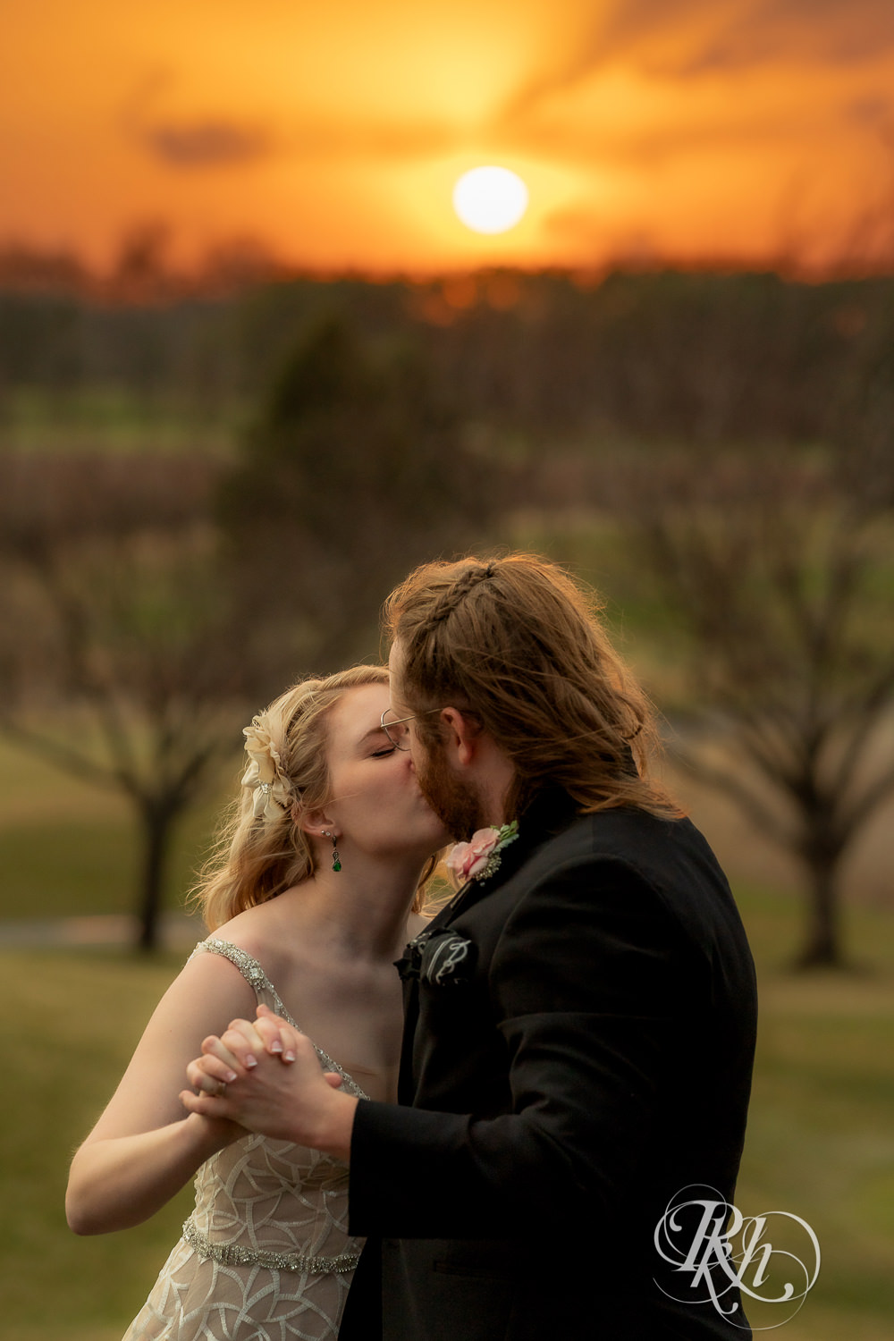 Bride and groom kiss at sunset at Rush Creek Golf Club in Maple Grove, Minnesota.