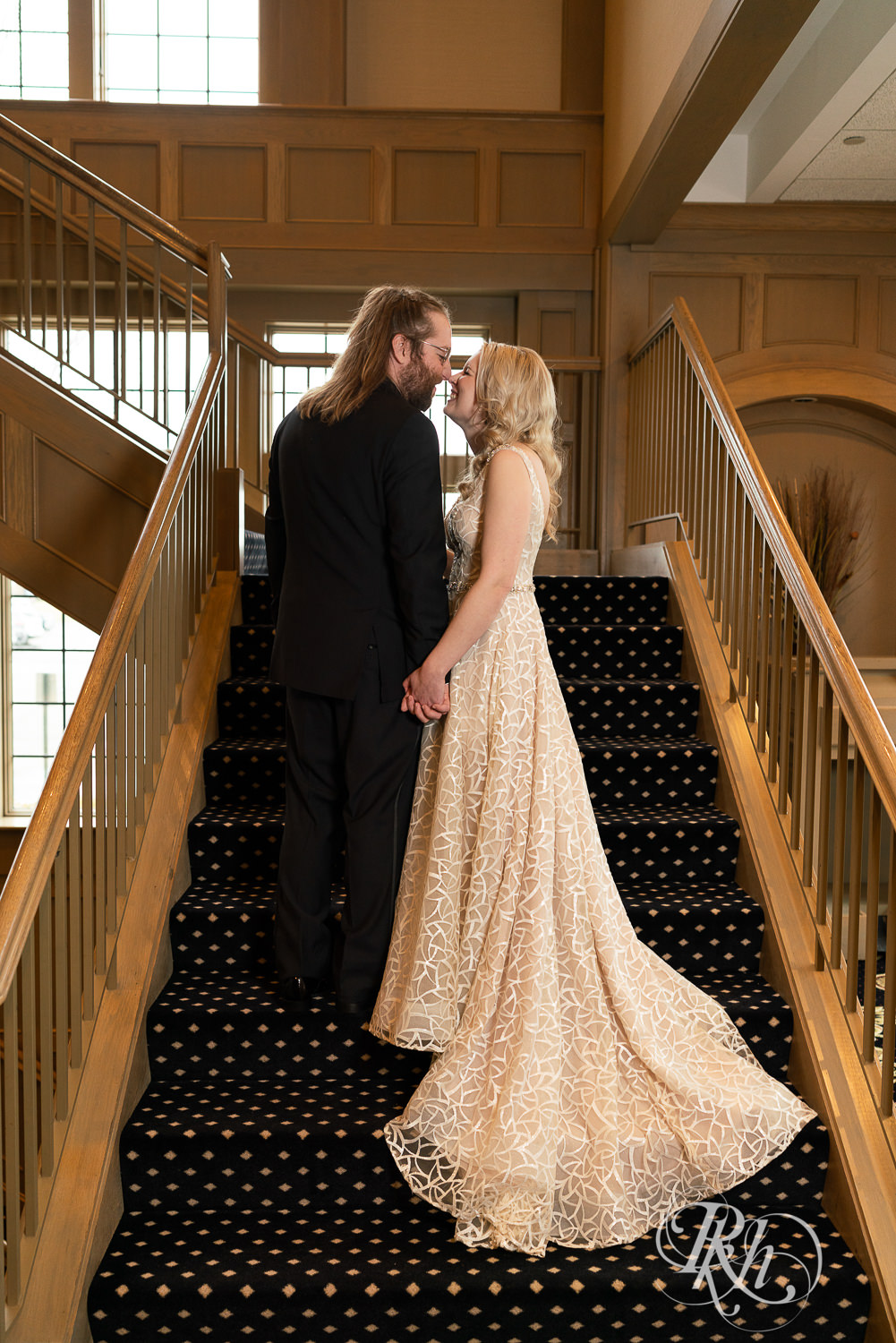 Bride and groom kiss on stairs at Rush Creek Golf Club in Maple Grove, Minnesota.