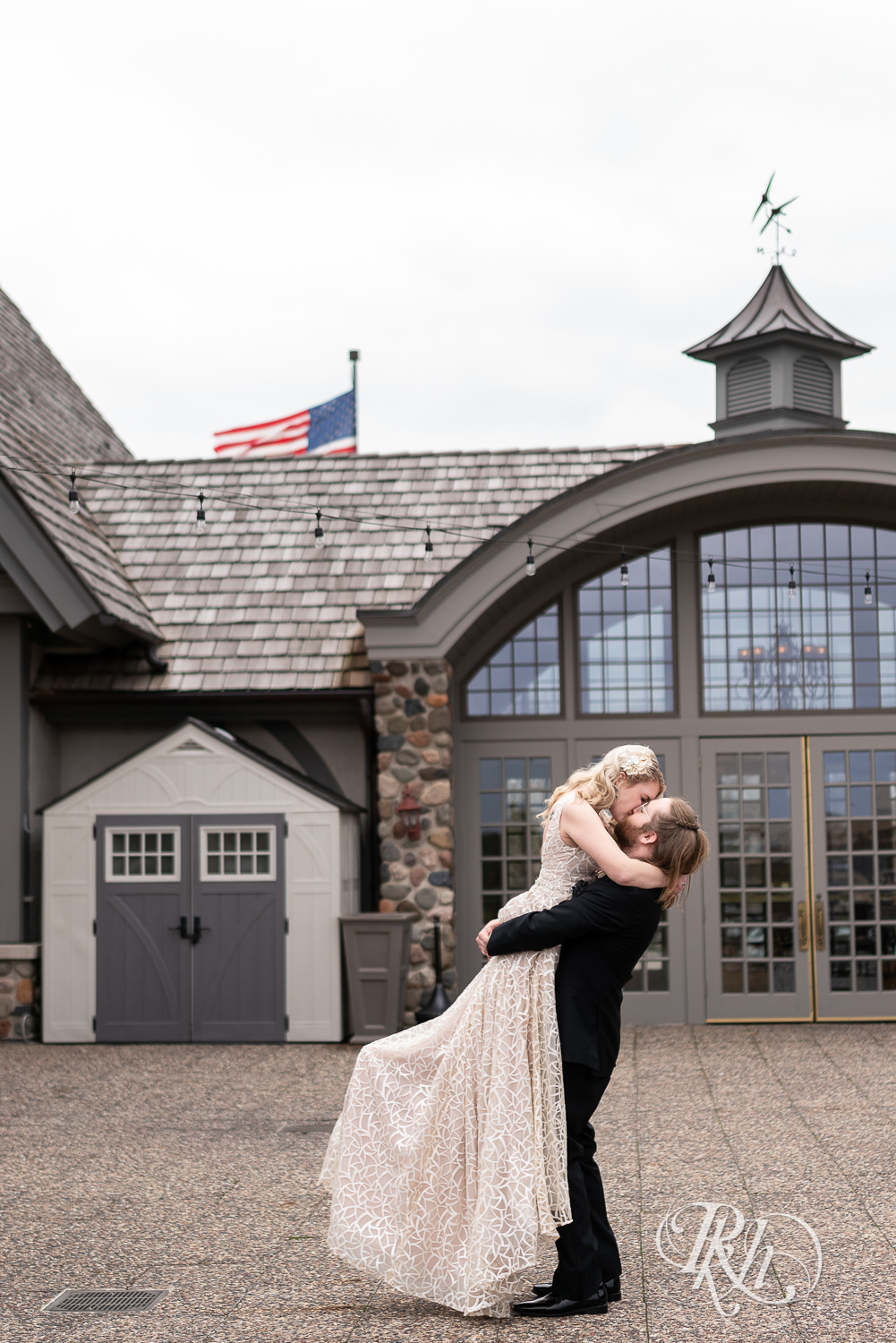 Groom lifts and kisses bride outside at Rush Creek Golf Club in Maple Grove, Minnesota.