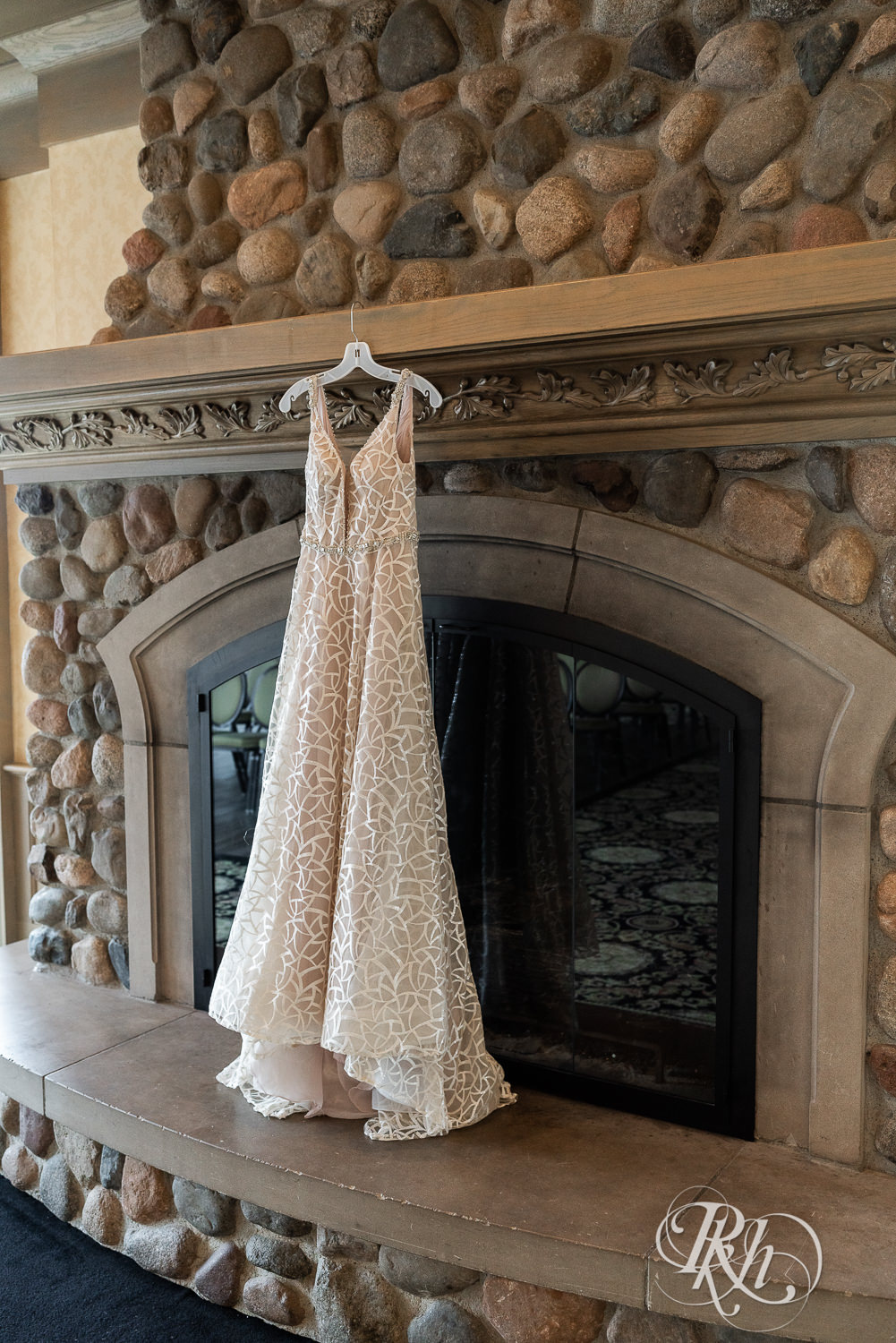 Wedding dress hanging on fireplace at Rush Creek Golf Club in Maple Grove, Minnesota.