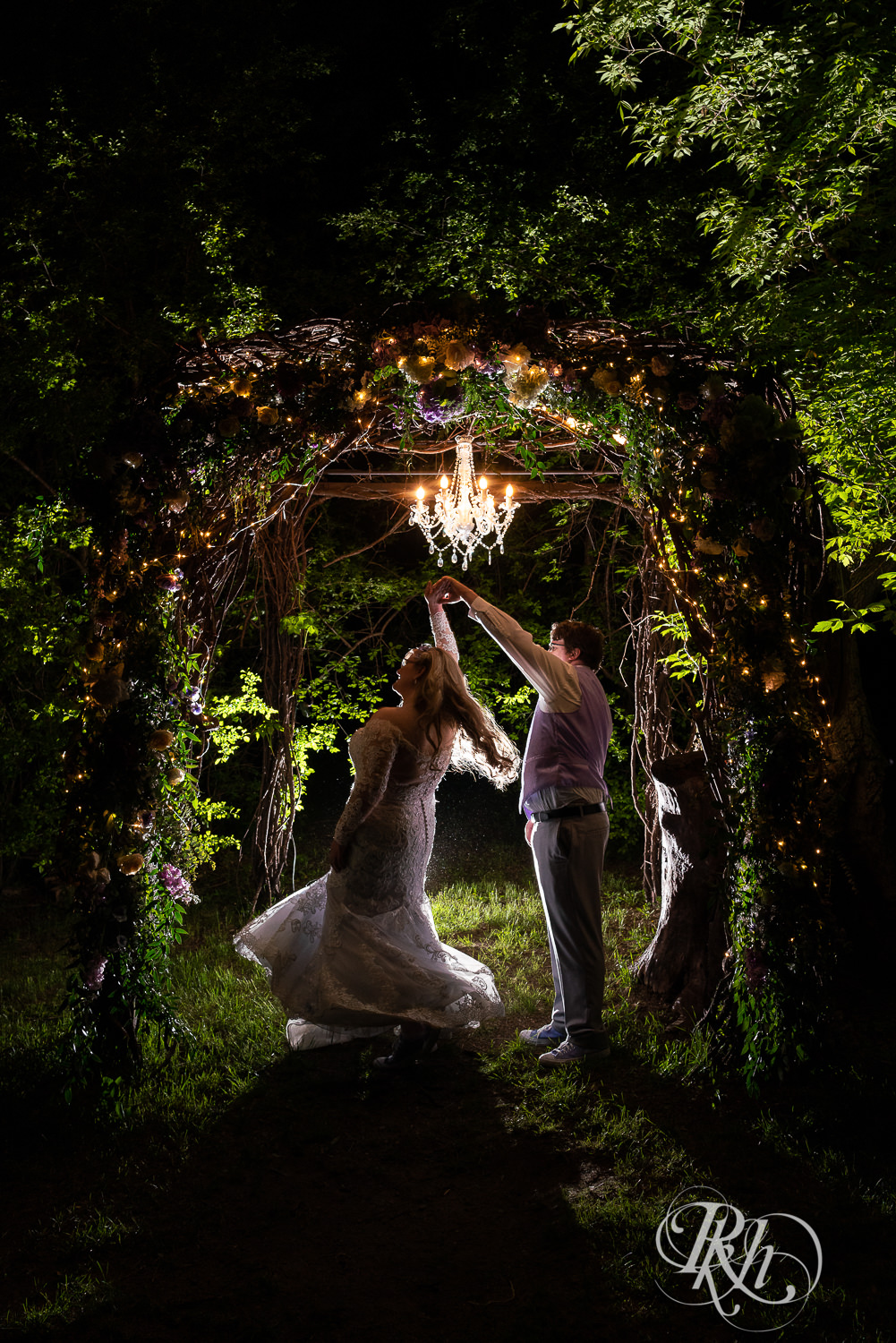 Bride and groom dance at night under lit alter at Hope Glen Farm in Cottage Grove, Minnesota.