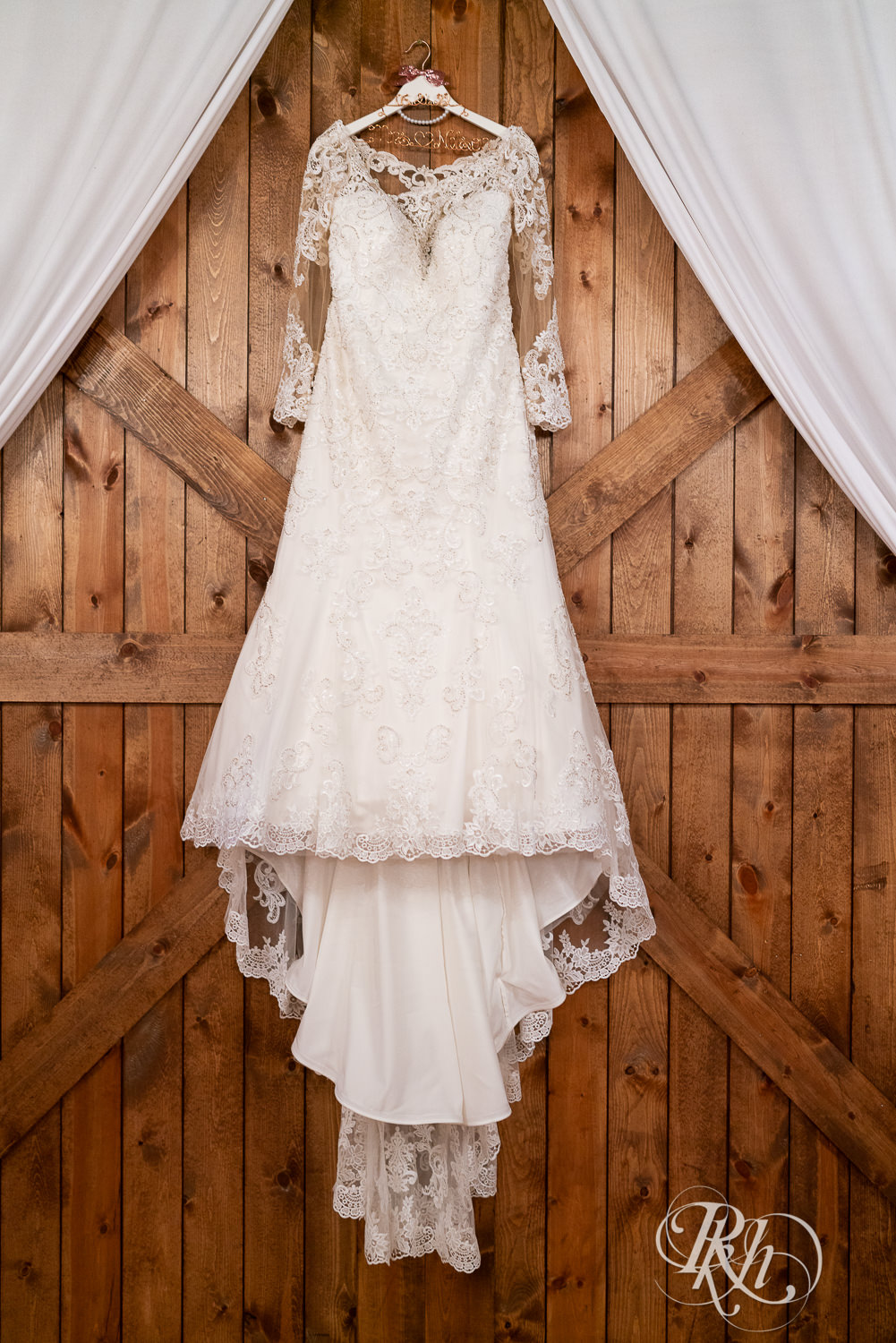 Wedding dress hanging on barn door at Hope Glen Farm in Cottage Grove, Minnesota.