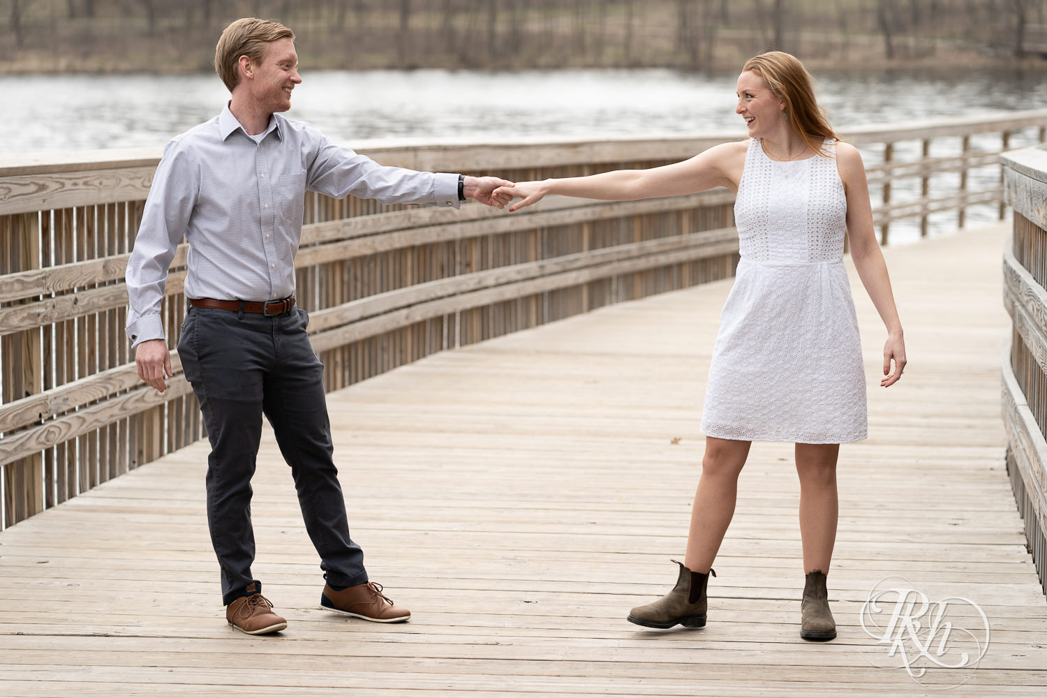 Man and woman dance on bridge on cloudy day in Eagan, Minnesota.