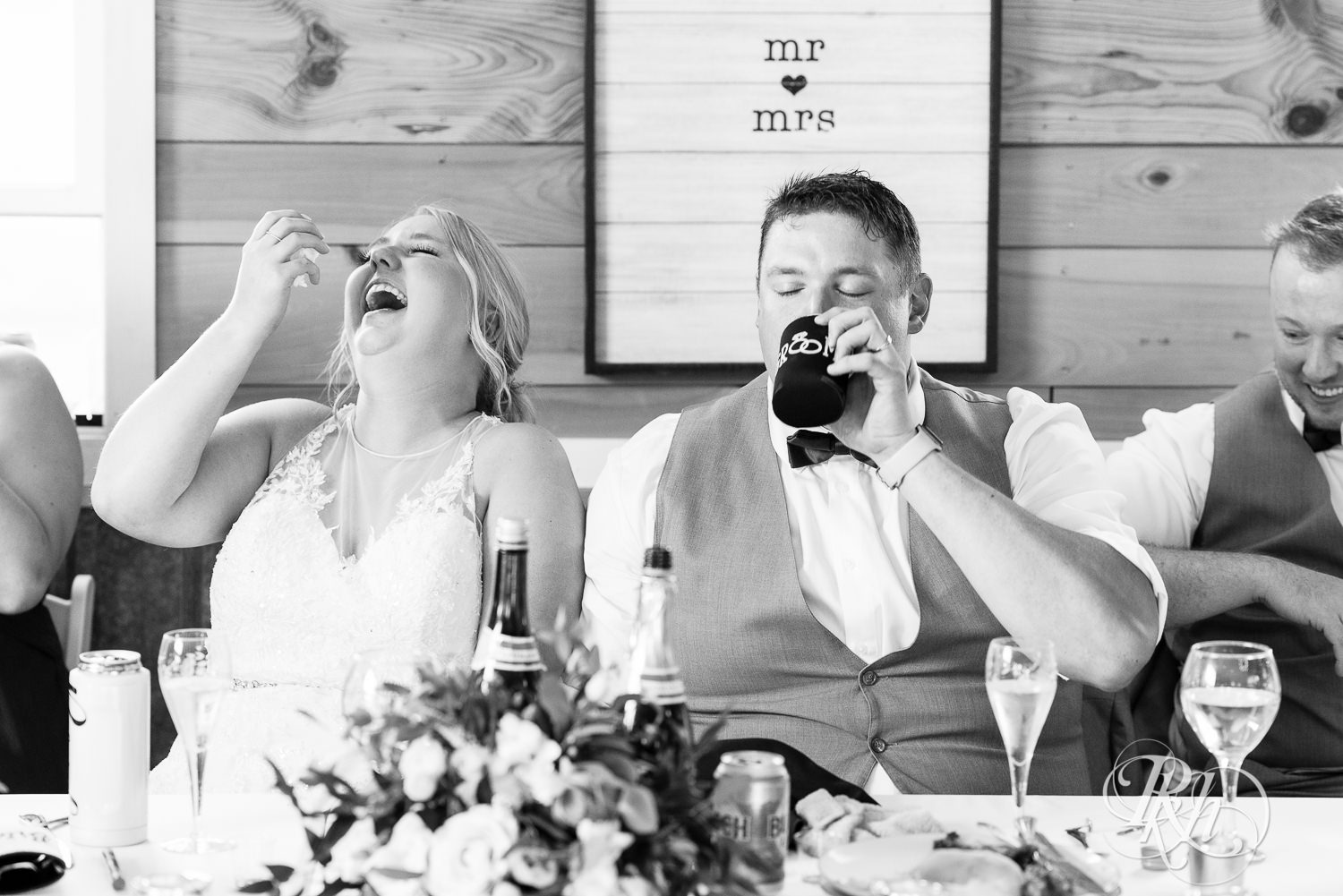 Bride and groom laughing during reception at Barn at Mirror Lake in Mondovi, Wisconsin.