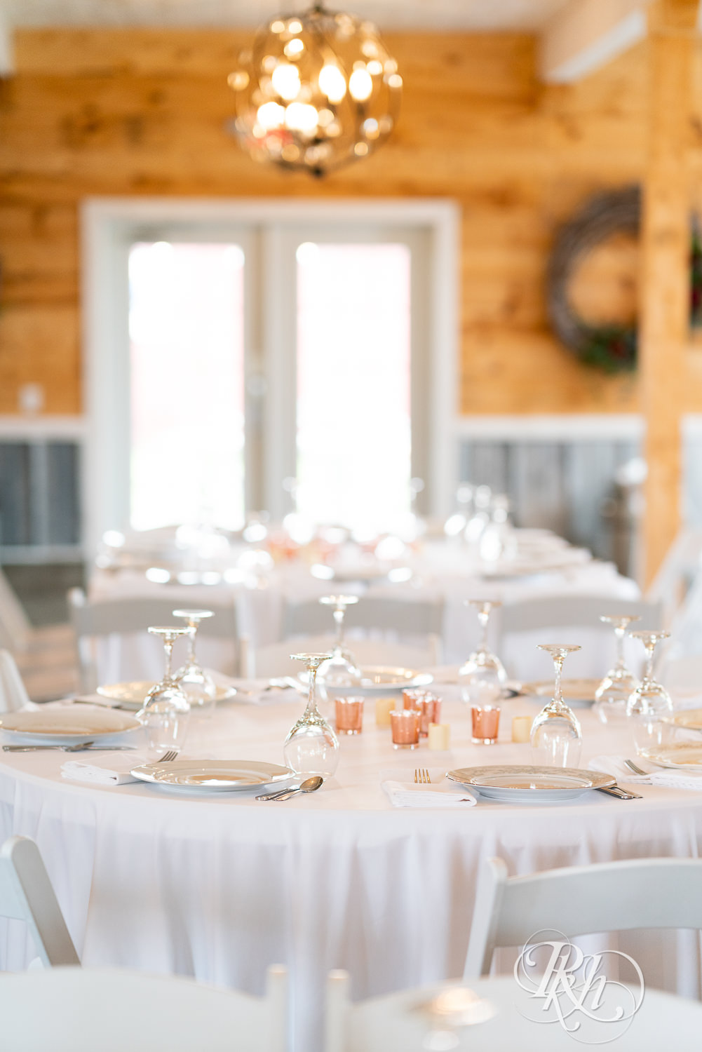 Indoor barn wedding reception setup at Barn at Mirror Lake in Mondovi, Wisconsin.