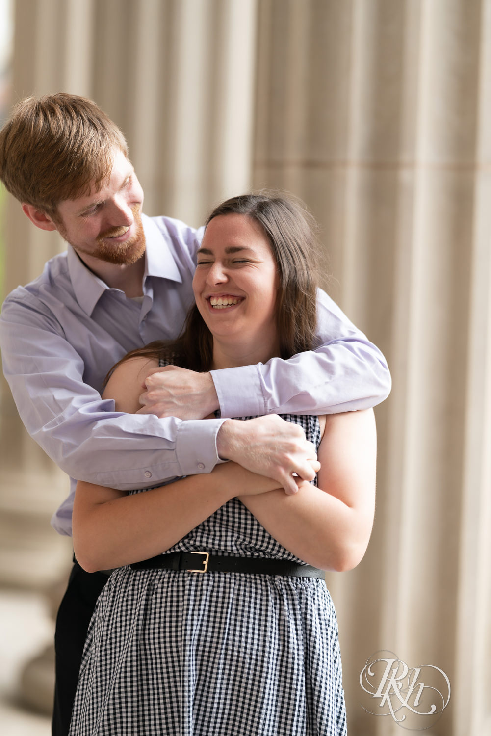 Man and woman laughing during engagement session at University of Minnesota.