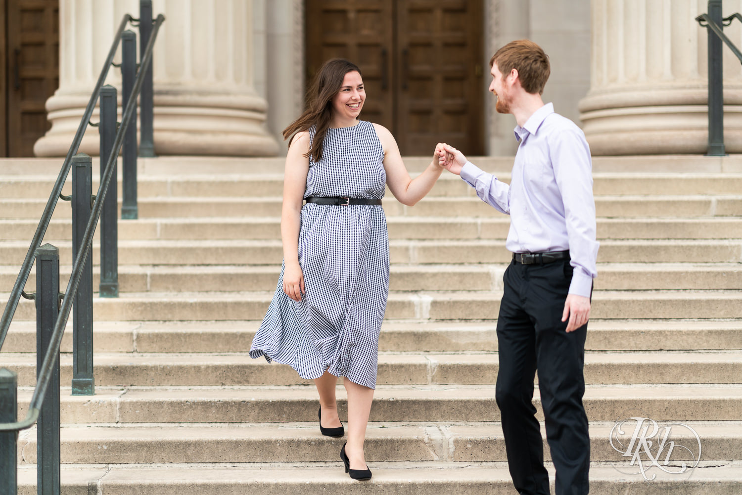 Man and woman walking down stairs during engagement session at University of Minnesota.