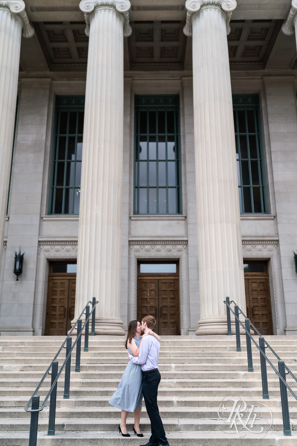 Man and woman kissing on stairs during engagement session at University of Minnesota.