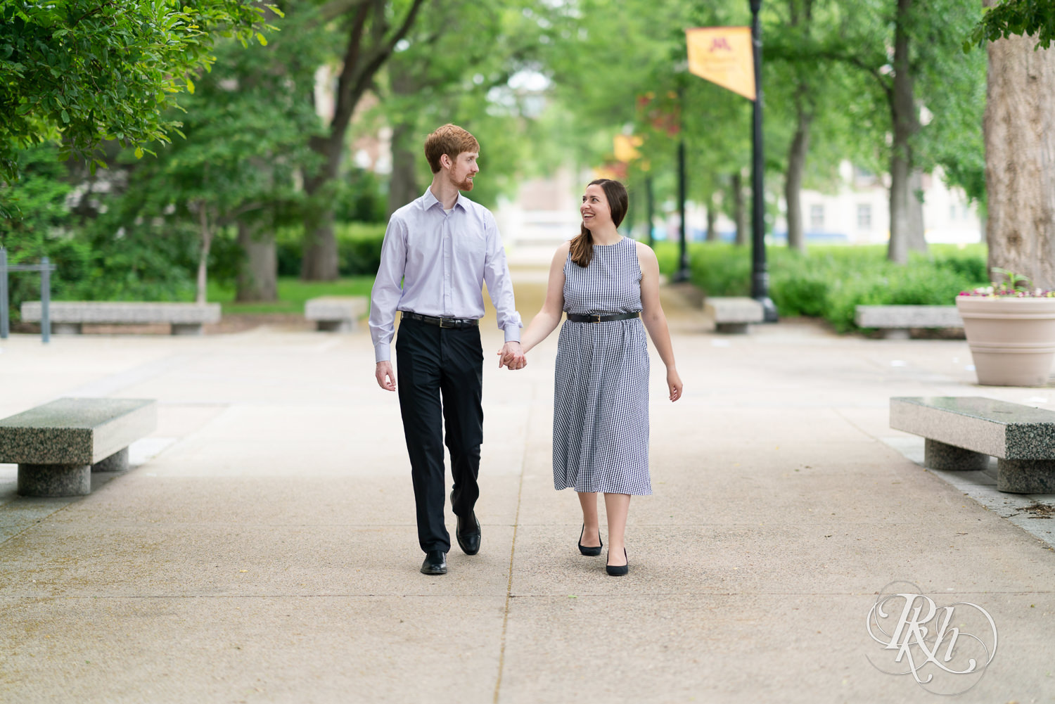 Man and woman walking and lauging during engagement session at University of Minnesota.