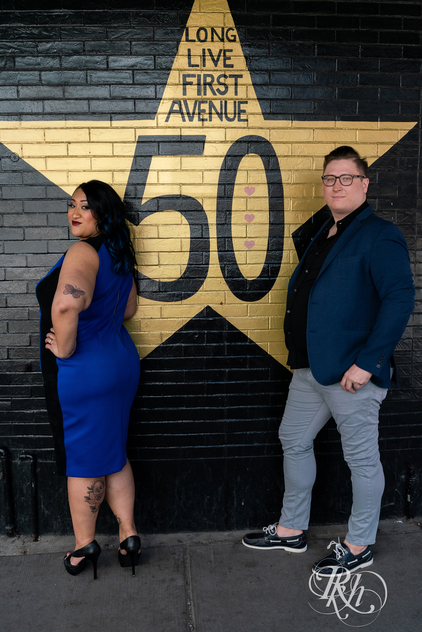 Man and Filipino woman standing in front of First Avenue in Minneapolis for engagement session.
