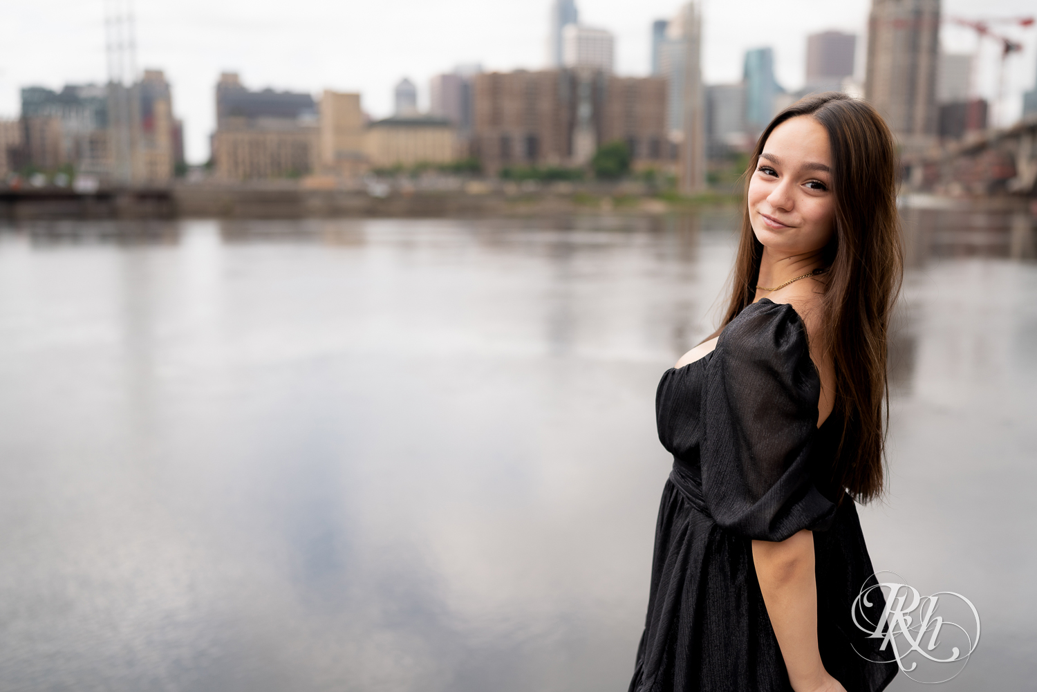 Lexi posing in a dress dress for senior photography in Minneapolis, Minnesota with the skyline in the background.