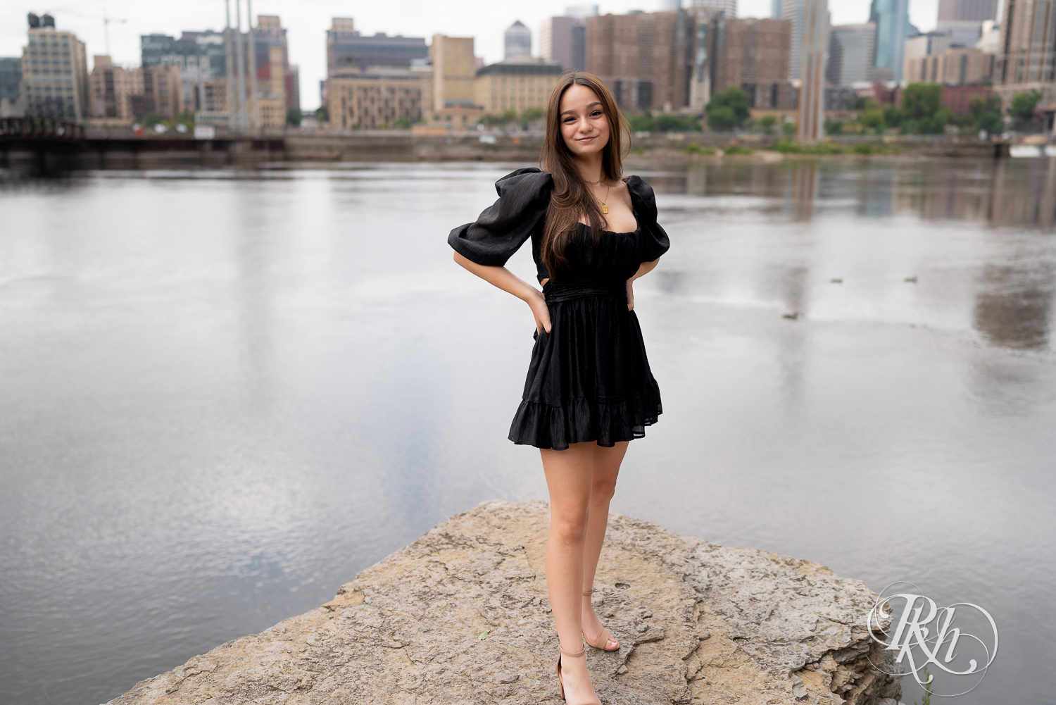 Lexi posing in a dress dress for senior photography in Minneapolis, Minnesota with the skyline in the background.