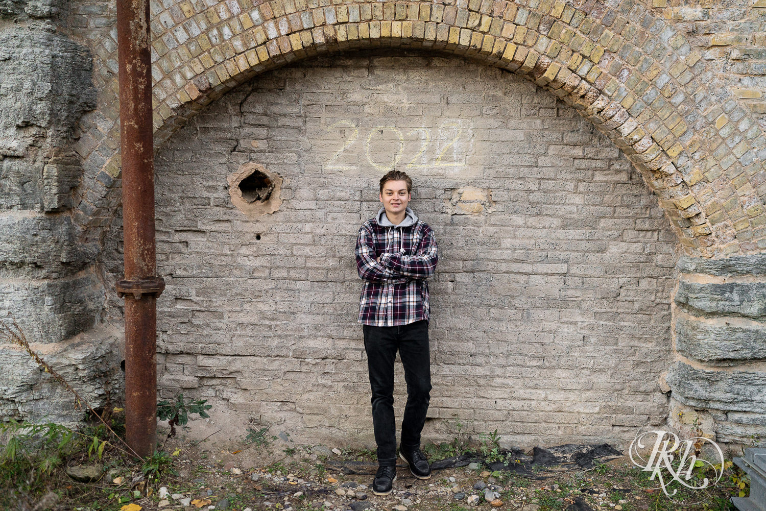 Senior boy dressed in flannel in Mill City Ruins in Minneapolis, Minnesota for senior photography