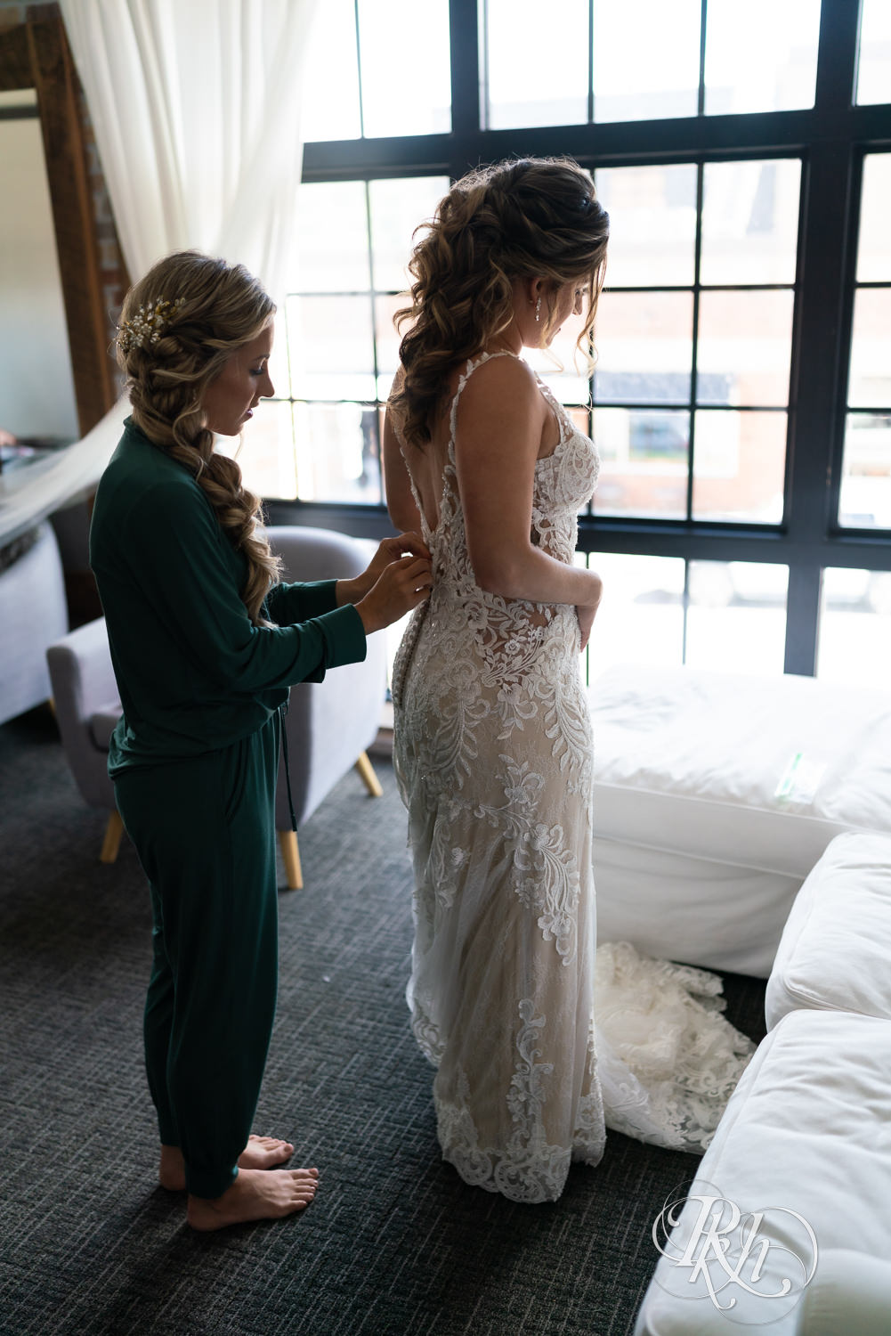 Bride getting buttoned into dress at Hotel Crosby in Stillwater, Minnesota.