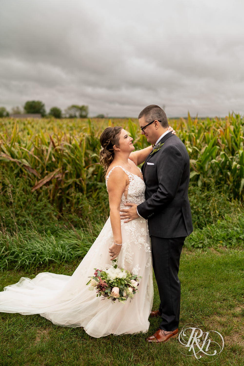 Bride and groom looking at each other in front of cornfield at Glenhaven Events in Farmington, Minnesota.