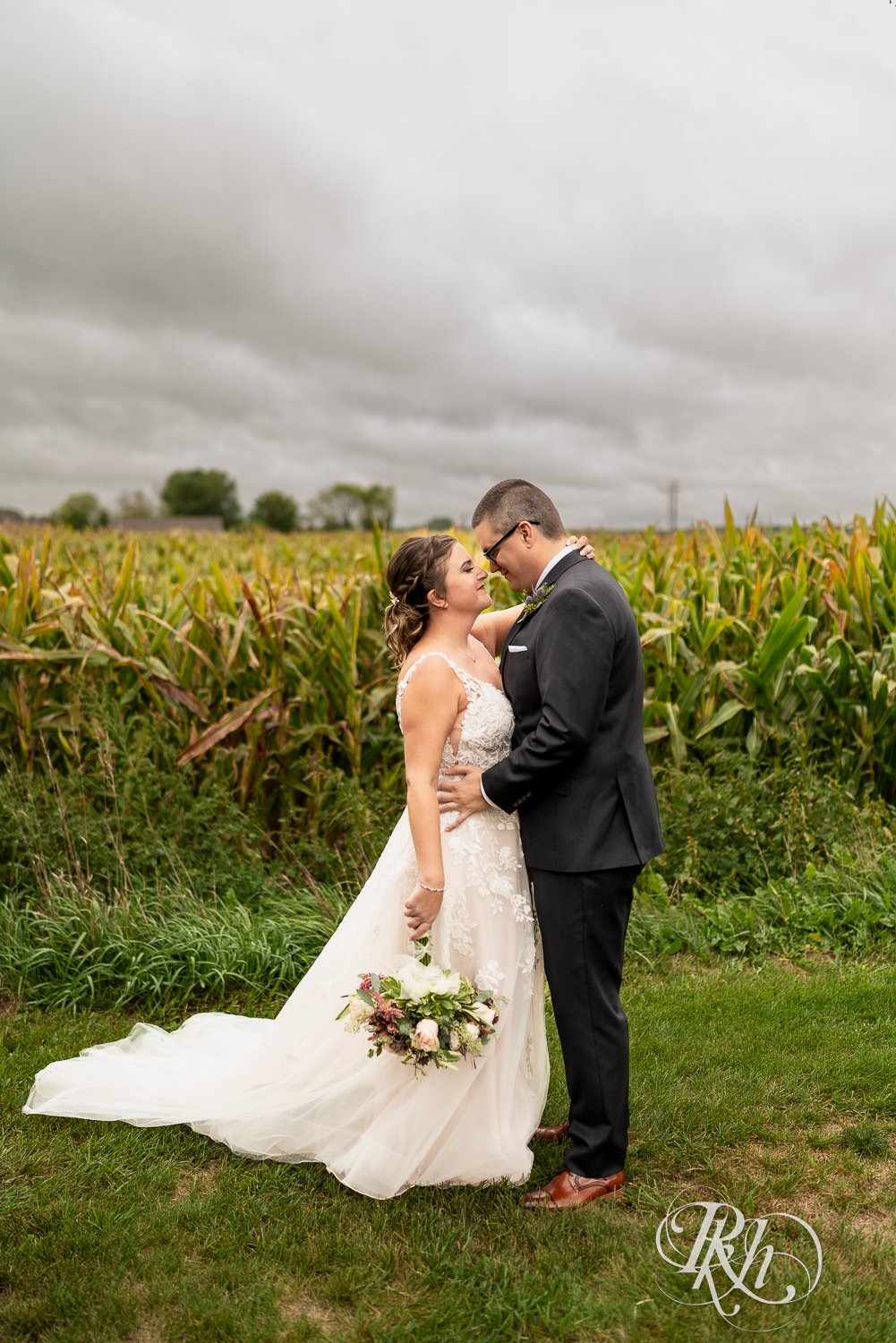 Bride and groom looking at each other in front of cornfield at Glenhaven Events in Farmington, Minnesota.