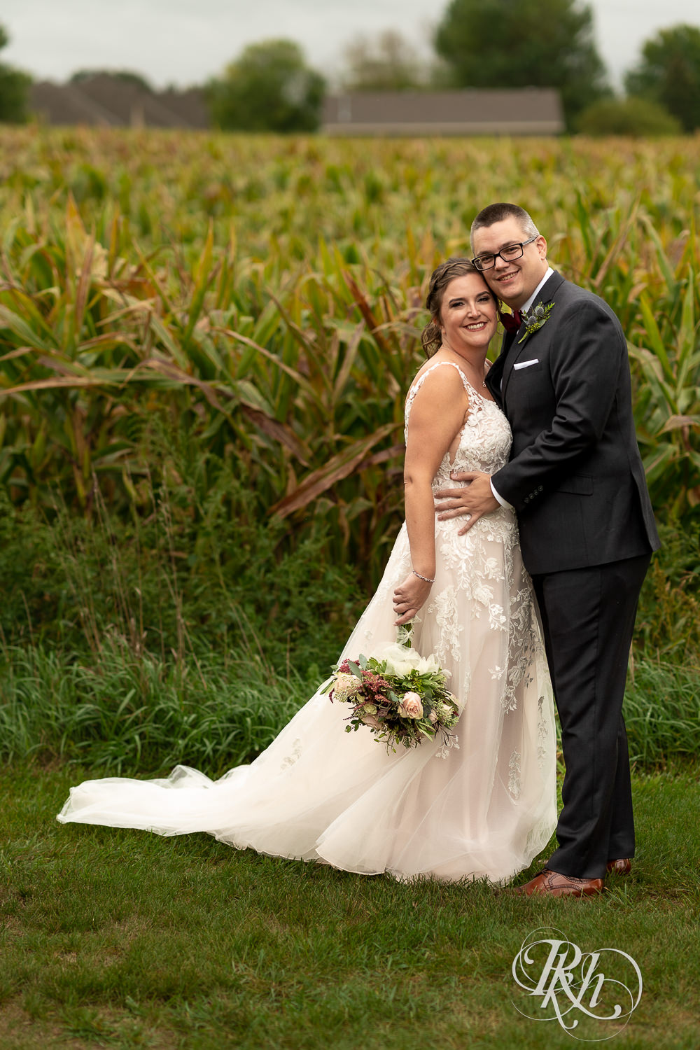 Bride and groom holding each other in front of cornfield at Glenhaven Events in Farmington, Minnesota.