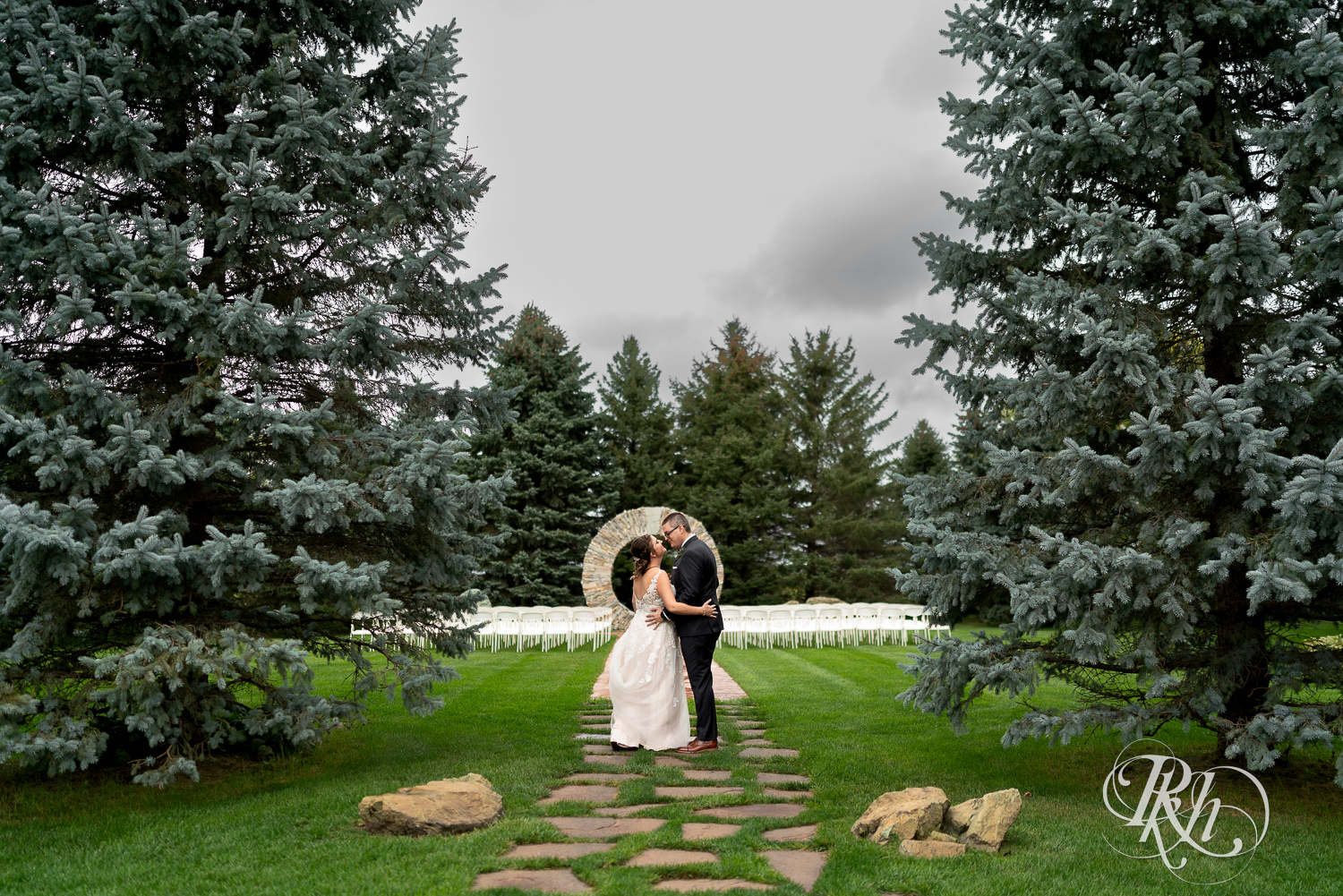 Bride and groom kissing each other on rainy day at Glenhaven Events in Farmington, Minnesota.