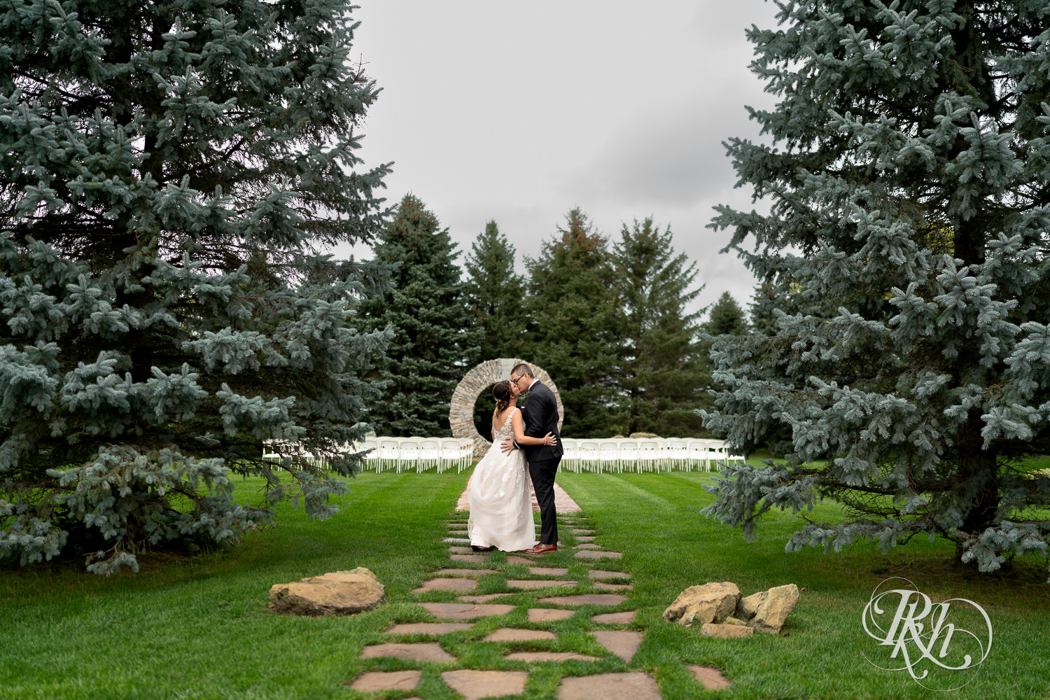 Bride and groom kissing each other on rainy day at Glenhaven Events in Farmington, Minnesota.