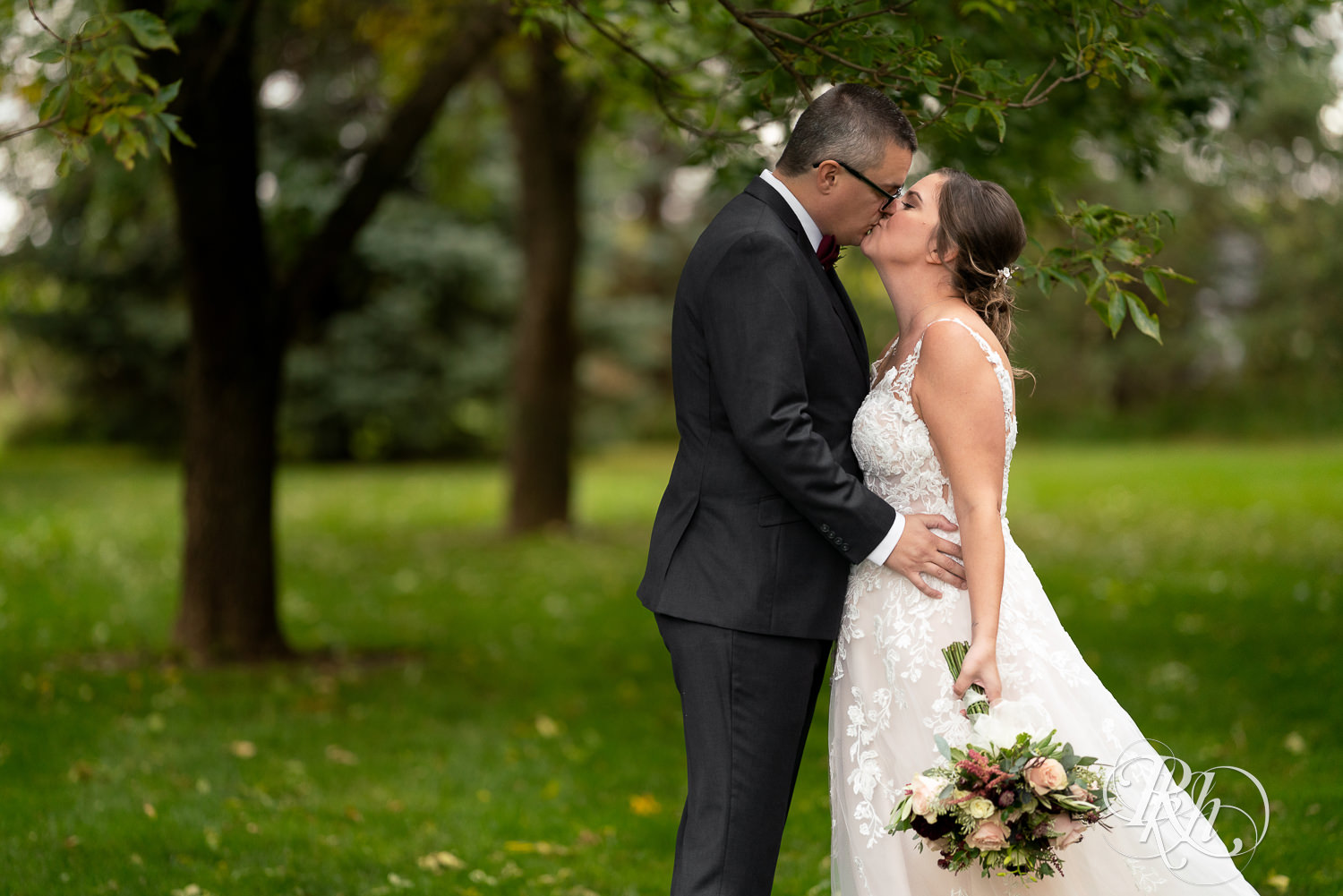 Bride and groom kissing on rainy day at Glenhaven Events in Farmington, Minnesota.
