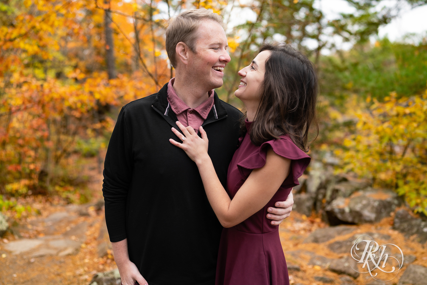 Annalyse and Brent looking at each other laughing at their sunrise engagement session in Taylors Falls, Minnesota.