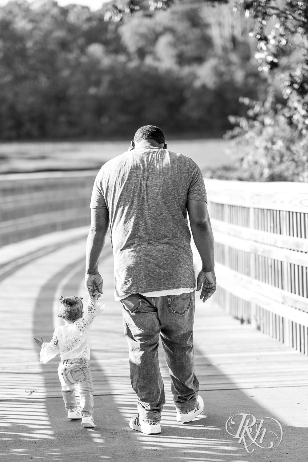 Dad walking with his baby girl holding hands in Lebanon Hills in Eagan, Minnesota.