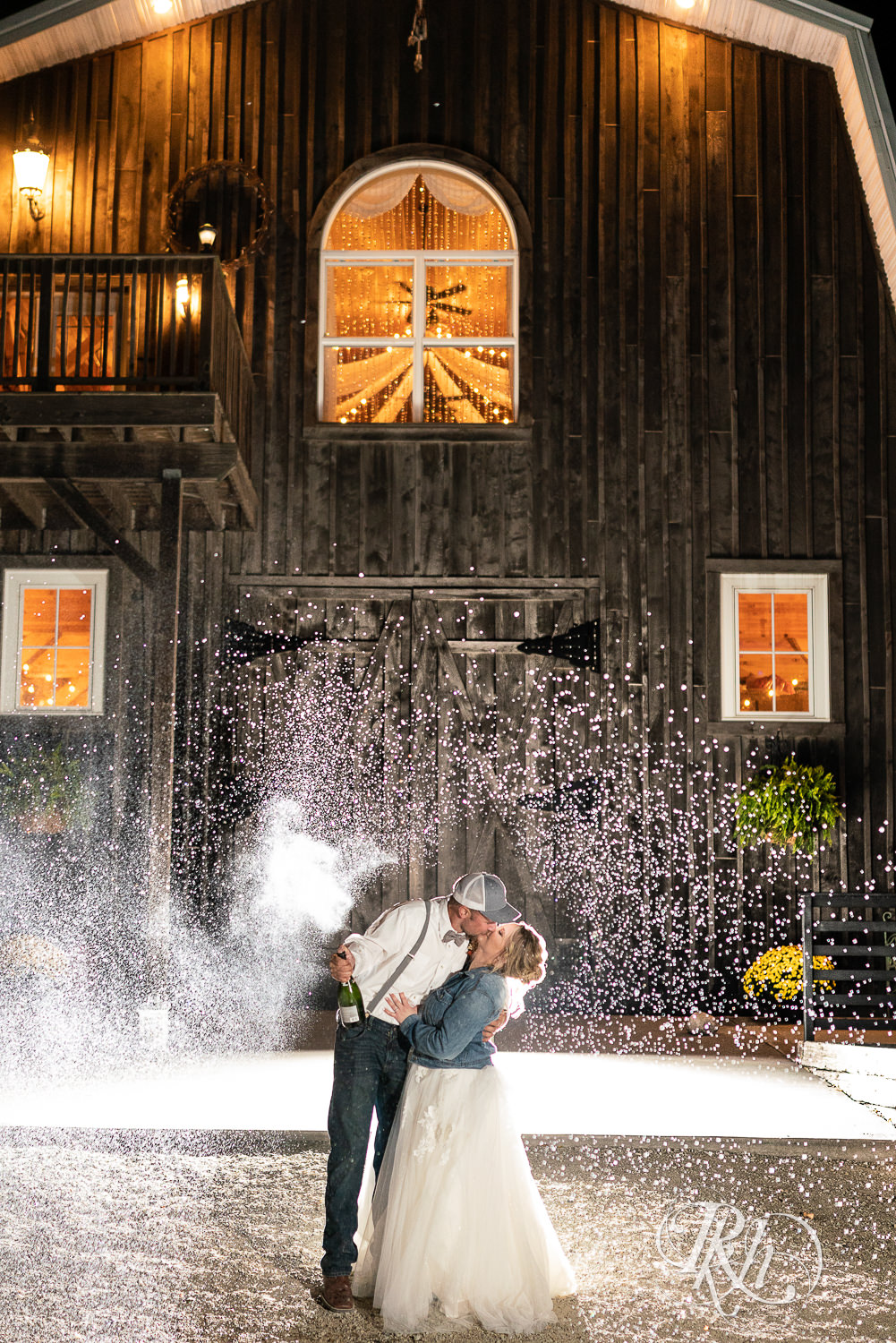 Bride and groom spray champagne at Barn at Crocker's Creek in Faribault, Minnesota.