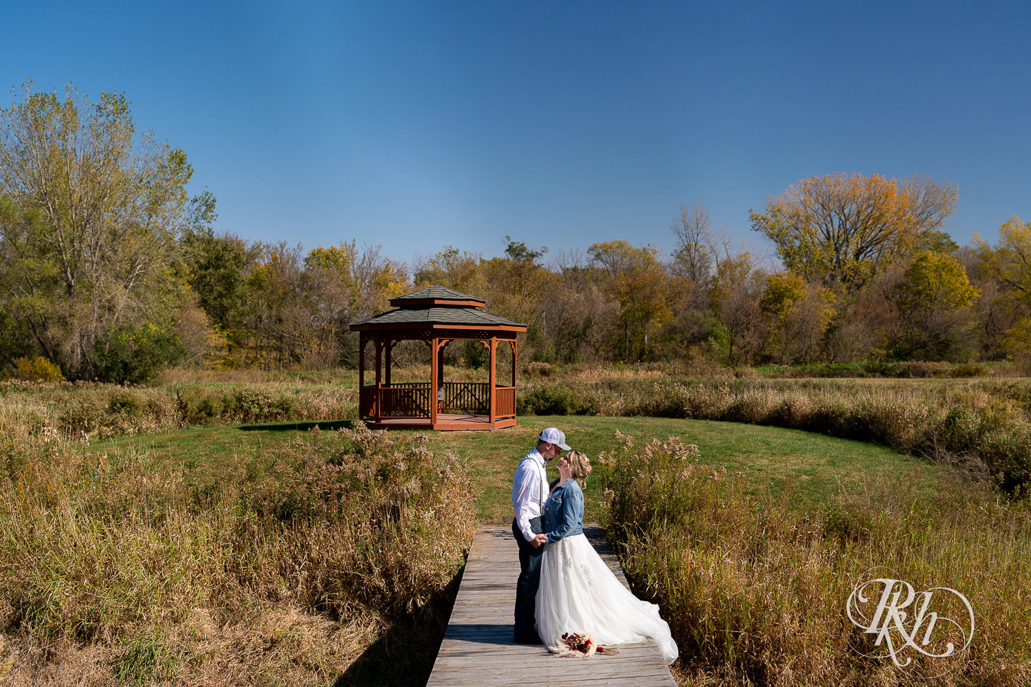 Bride and groom facing each other on bridge at Barn at Crocker's Creek in Faribault, Minnesota.