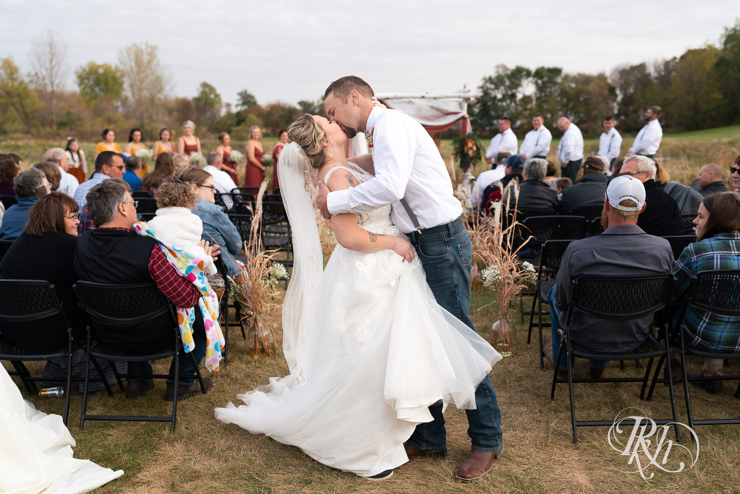 Husband and wife kiss at end of the aisle Barn at Crocker's Creek in Faribault, Minnesota.