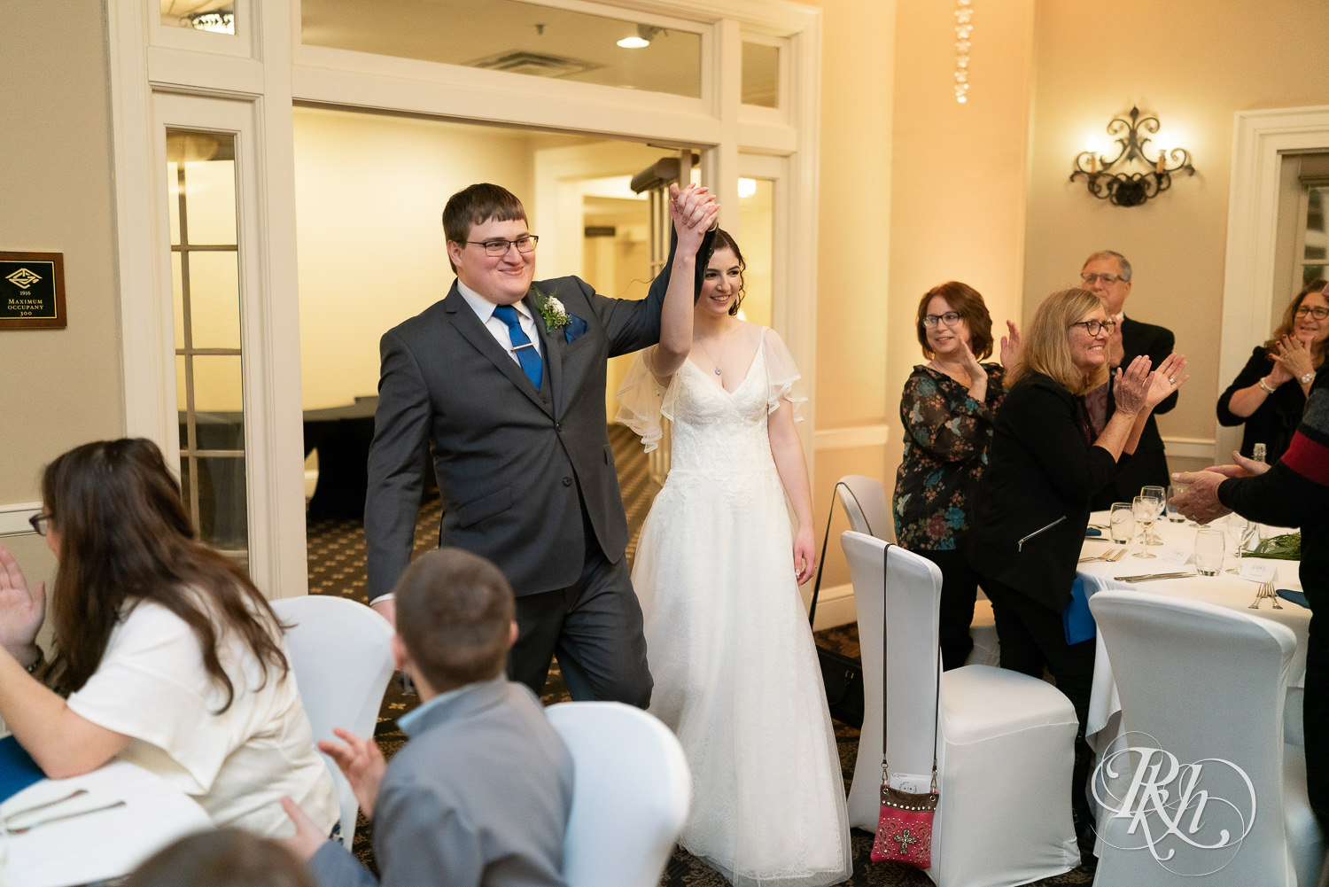 Bride and groom enter wedding reception at Minneapolis Golf Club in Saint Louis Park, Minnesota.