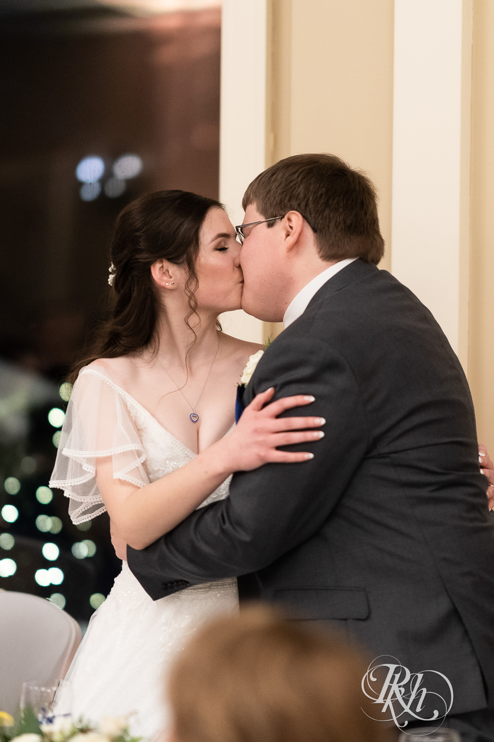 Bride and groom kiss at wedding reception at Minneapolis Golf Club in Saint Louis Park, Minnesota.