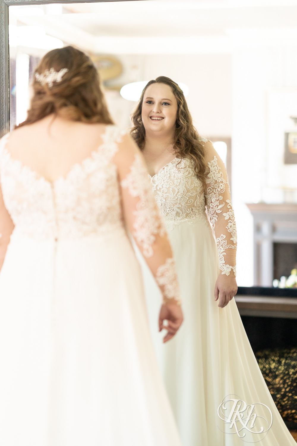 Bride smiling in mirror at Semple Mansion in Minneapolis, Minnesota.