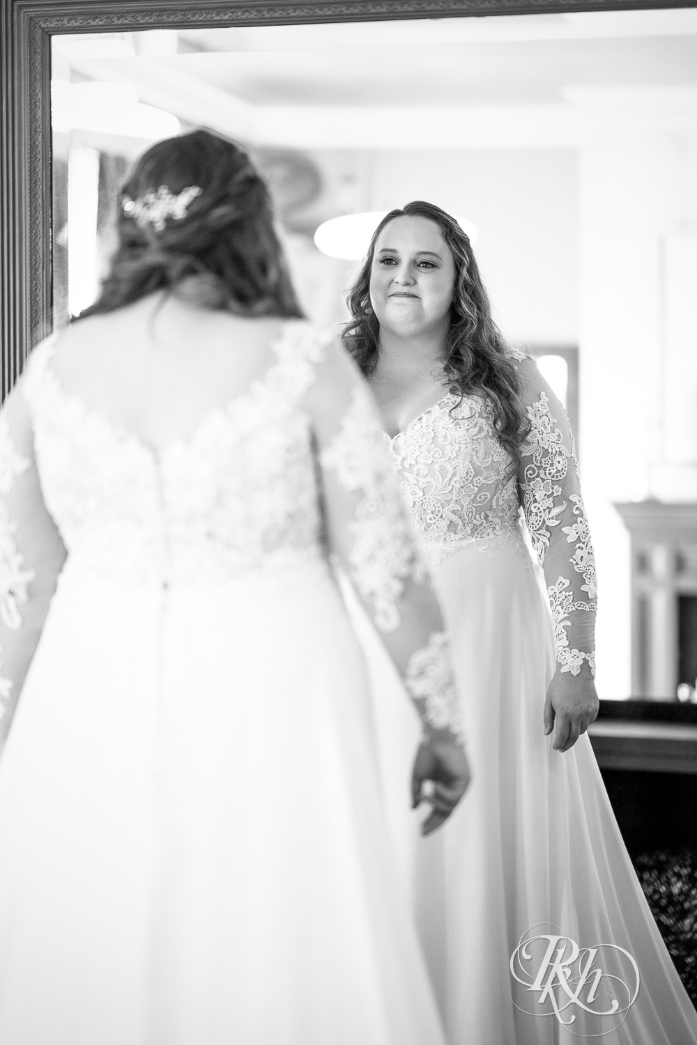 Bride smiling in mirror at Semple Mansion in Minneapolis, Minnesota.